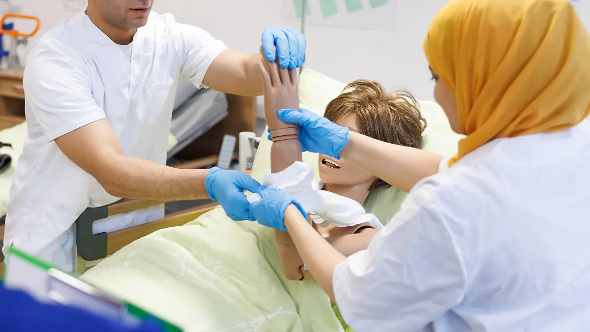 PRODUKTION - 24.01.2024, Nordrhein-Westfalen, Petershagen: Ausländische Pflegefachkräfte in Anerkennung nehmen Teil an einem Praxistraining zur Körperpflege. Auf dem Iuvare Pflegecampus werden Pflegekräfte aus dem Ausland fit gemacht für die Arbeit in deutschen Kliniken, Heimen und ambulanten Diensten. In einem Intensivkurs werden sie in deutschen Pflegestandards geschult und bei ihrem Weg in den Beruf in Deutschland begleitet. (zu dpa «Fachkräftekongress «Mehr Power fürs Fachkräfteland» des Bundesministerium für Arbeit und Soziales») Foto: Friso Gentsch/dpa +++ dpa-Bildfunk +++