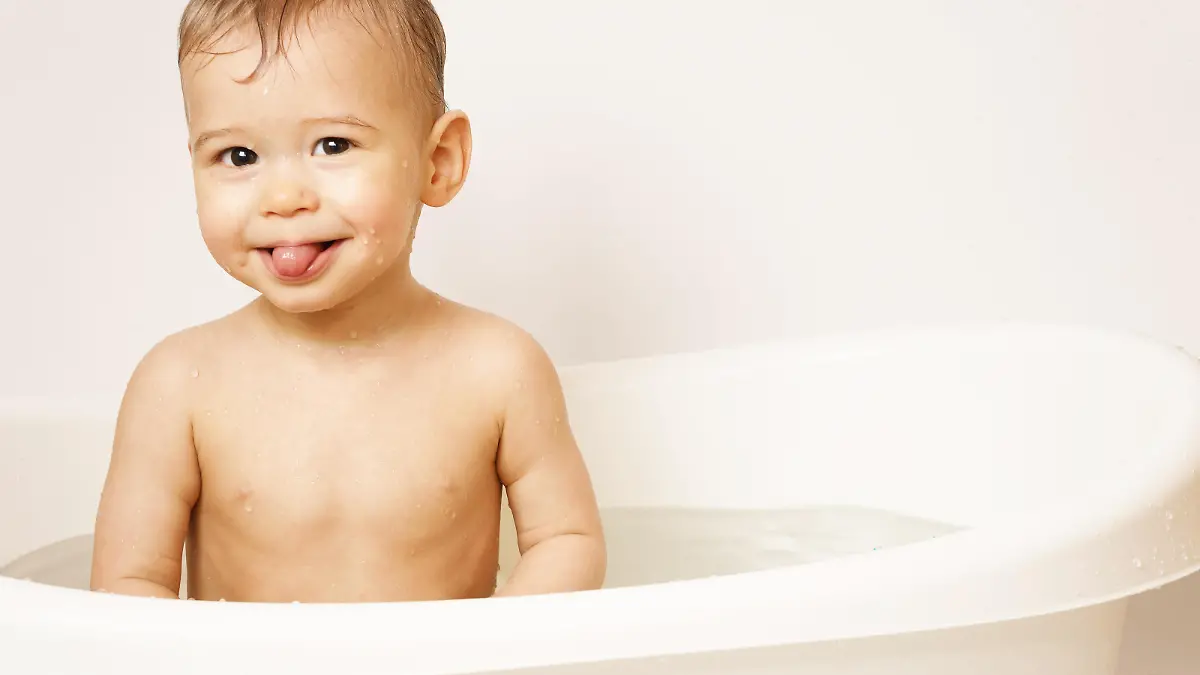 Adorable smiling little boy is sticking a tongue while taking a bath in warm water. || Modellfreigabe vorhanden
