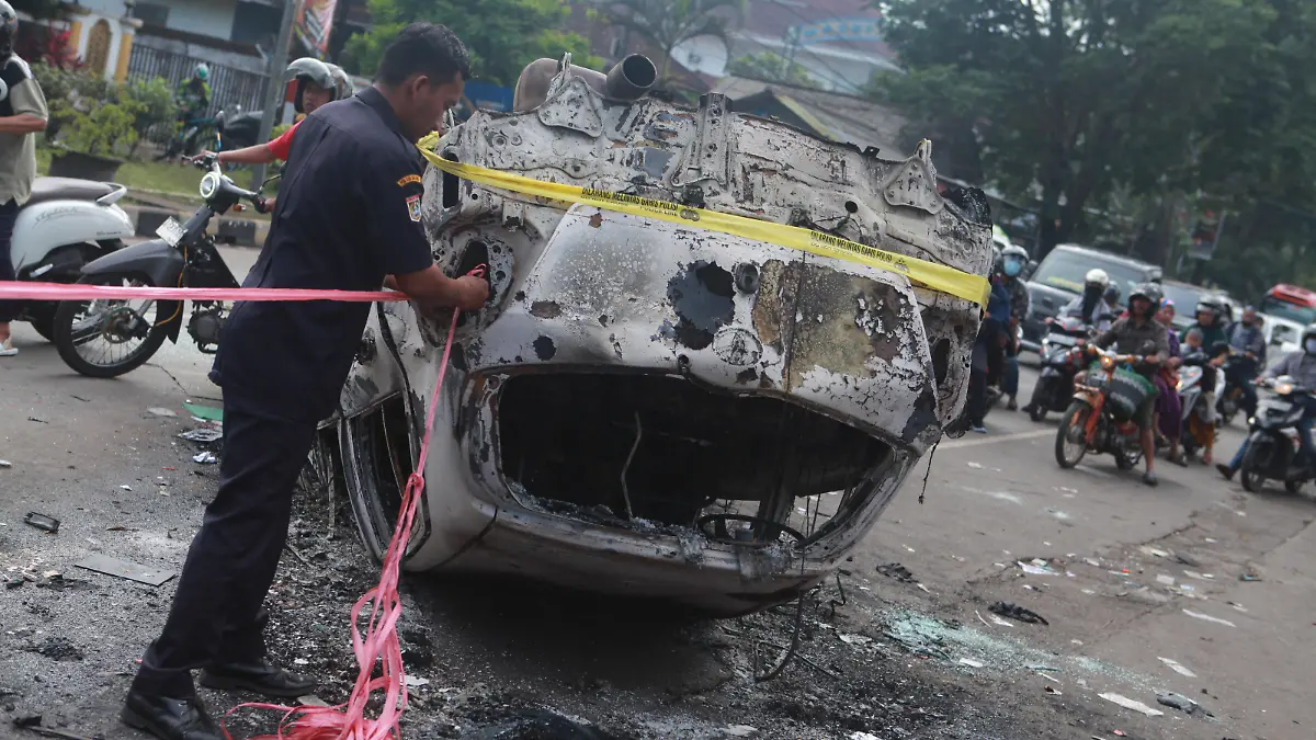 221002 -- MALANG, Oct. 2, 2022 -- A police officer ties a rope on the wreckage of a burned car outside the Kanjuruhan Stadium in Malang of East Java province, Indonesia, Oct. 2, 2022. At least 129 people were killed and 180 others injured after a stampede and clashes at a football match in Indonesia s Malang, East Java province on Saturday evening, Indonesian police said on Sunday. Provincial police chief Nico Afinta said at a press conference that the chaos happened on late Saturday at the Kanjuruhan Stadium in Malang regency right after Arema Malang club lost to Persebaya Surabaya in the Indonesian Liga 1 football contest. Photo by /Xinhua INDONESIA-MALANG-FOOTBALL MATCH-STAMPEDE-CLASH-CASUALTIES BayuxNovanta PUBLICATIONxNOTxINxCHN