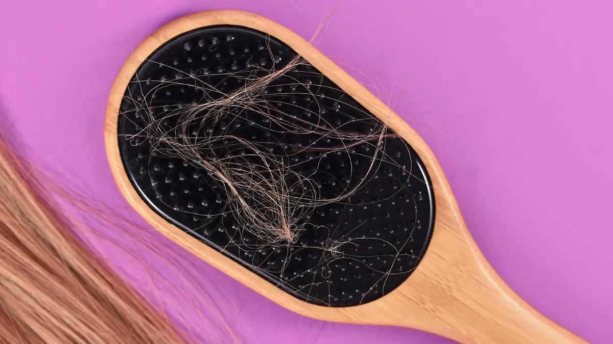 Concept for losing hair with strands of blond hair caught in hair brush