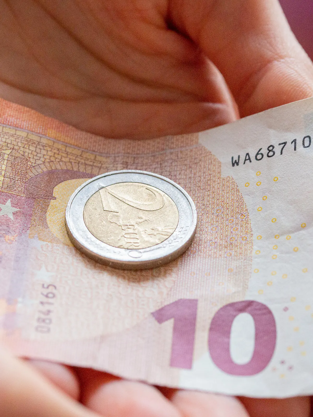 ARCHIV - 10.02.2022, Berlin: Eine Person hält 12 Euro in der Hand. Der gesetzliche Mindestlohn steigt zum 1. Oktober auf 12 Euro je Stunde von zuvor 10,45 Euro. Seit 2015 ist der Mindestlohn damit um mehr als 40 Prozent gestiegen. Foto: Fernando Gutierrez-Juarez/dpa-Zentralbild/dpa +++ dpa-Bildfunk +++