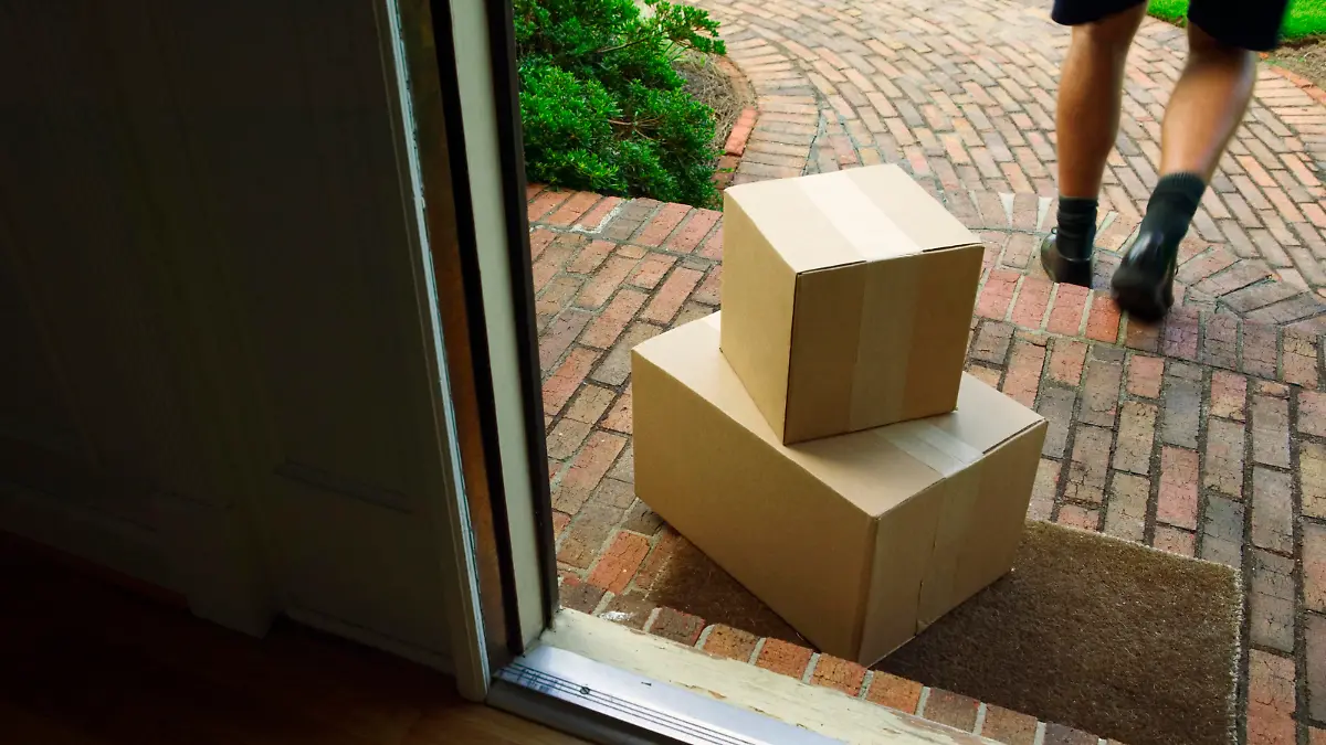 Paketbote legt Pakete vor Haustür ab