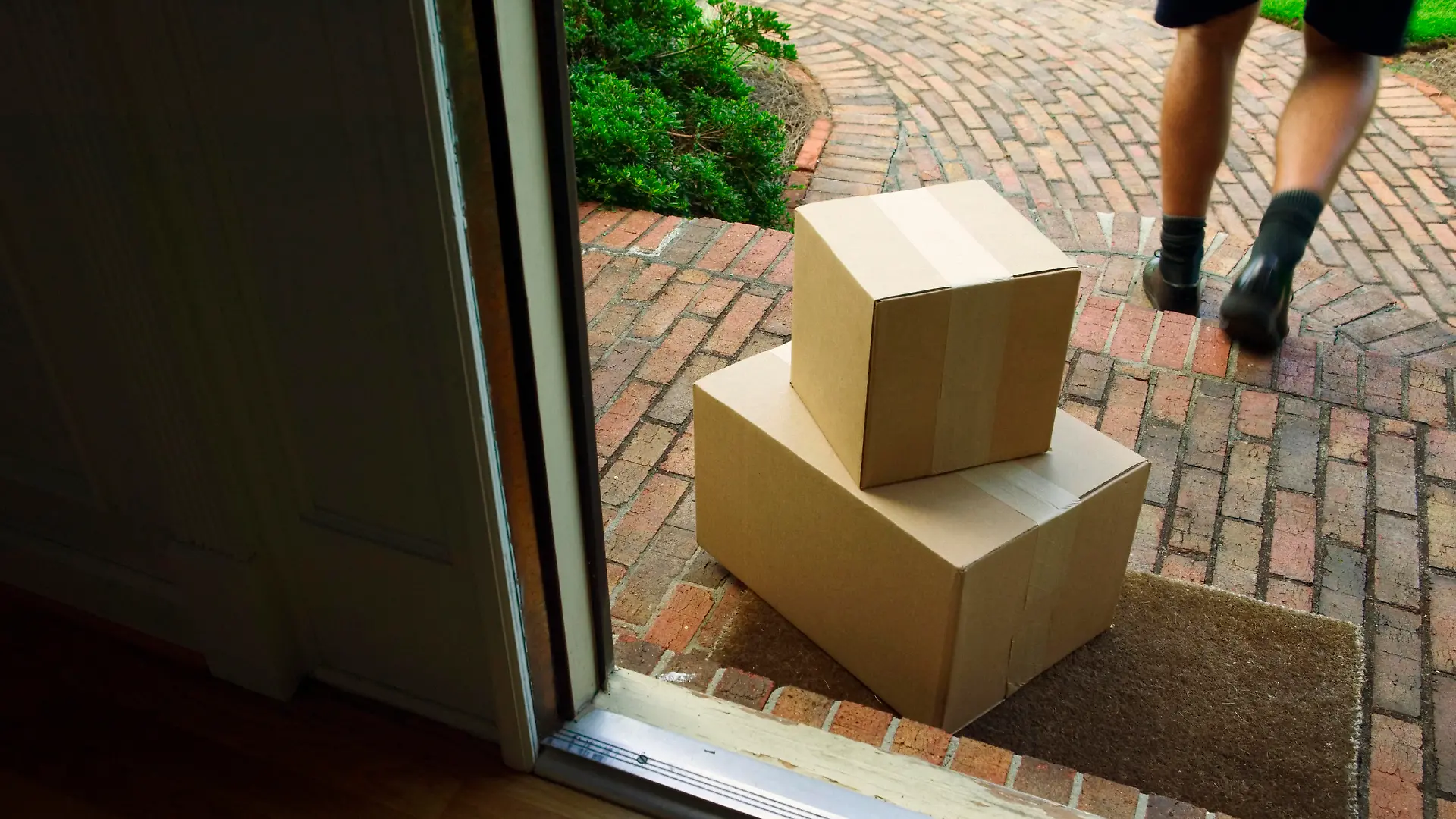 Paketbote legt Pakete vor Haustür ab