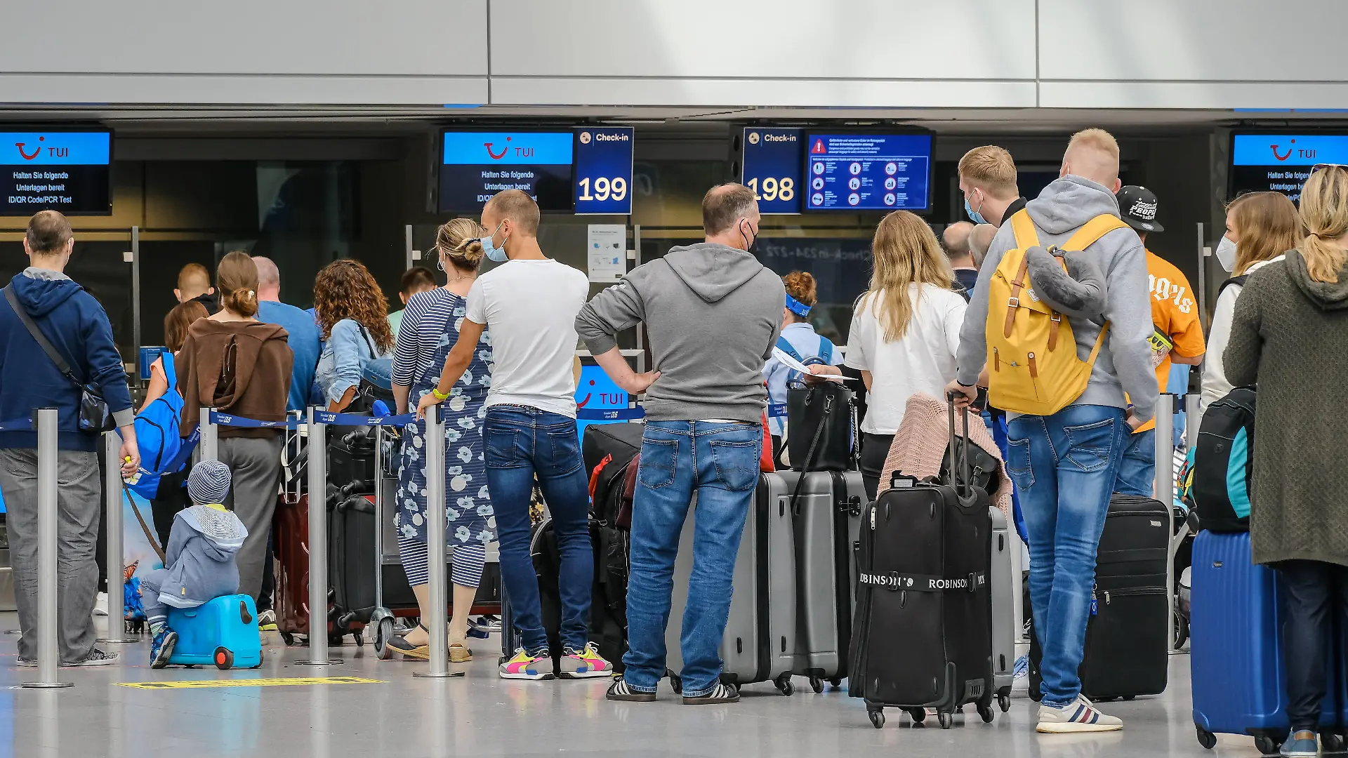 Duesseldorf, Nordrhein-Westfalen, Deutschland - Flughafen Duesseldorf, Ferienstart in NRW, Urlauber stehen mit Koffern in einer Menschenschlange am TUI Check-in Schalter in Zeiten der Coronapandemie auf dem Weg in den Sommerurlaub, Urlauber sollen PCR-Test, ID/QR-Code bereithalten. Düsseldorf Nordrhein-Westfalen Deutschland *** Duesseldorf, North Rhine Westphalia, Germany Duesseldorf Airport, start of holidays in NRW, holidaymakers stand with suitcases in a queue at the TUI check-in counter in times of the corona pandemic on the way to their summer holidays, holidaymakers should have PCR test, ID QR code ready Duesseldorf North Rhine Westphalia Germany