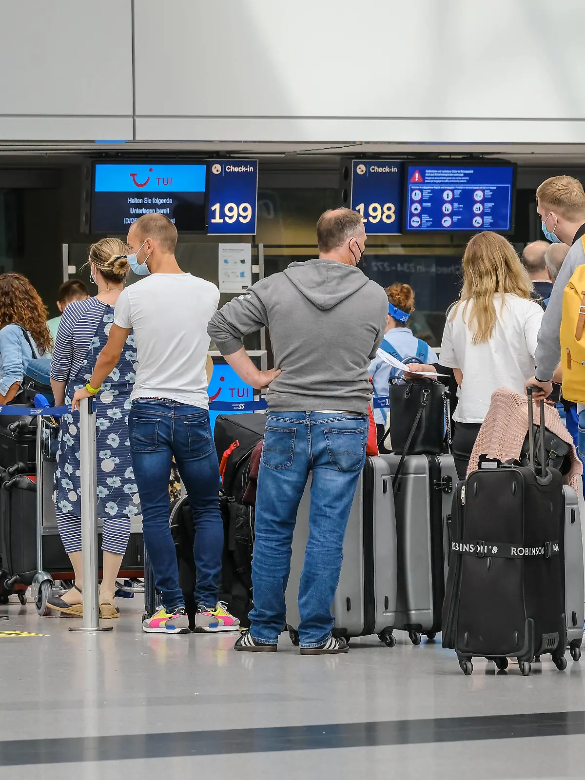 Duesseldorf, Nordrhein-Westfalen, Deutschland - Flughafen Duesseldorf, Ferienstart in NRW, Urlauber stehen mit Koffern in einer Menschenschlange am TUI Check-in Schalter in Zeiten der Coronapandemie auf dem Weg in den Sommerurlaub, Urlauber sollen PCR-Test, ID/QR-Code bereithalten. Düsseldorf Nordrhein-Westfalen Deutschland *** Duesseldorf, North Rhine Westphalia, Germany Duesseldorf Airport, start of holidays in NRW, holidaymakers stand with suitcases in a queue at the TUI check-in counter in times of the corona pandemic on the way to their summer holidays, holidaymakers should have PCR test, ID QR code ready Duesseldorf North Rhine Westphalia Germany 