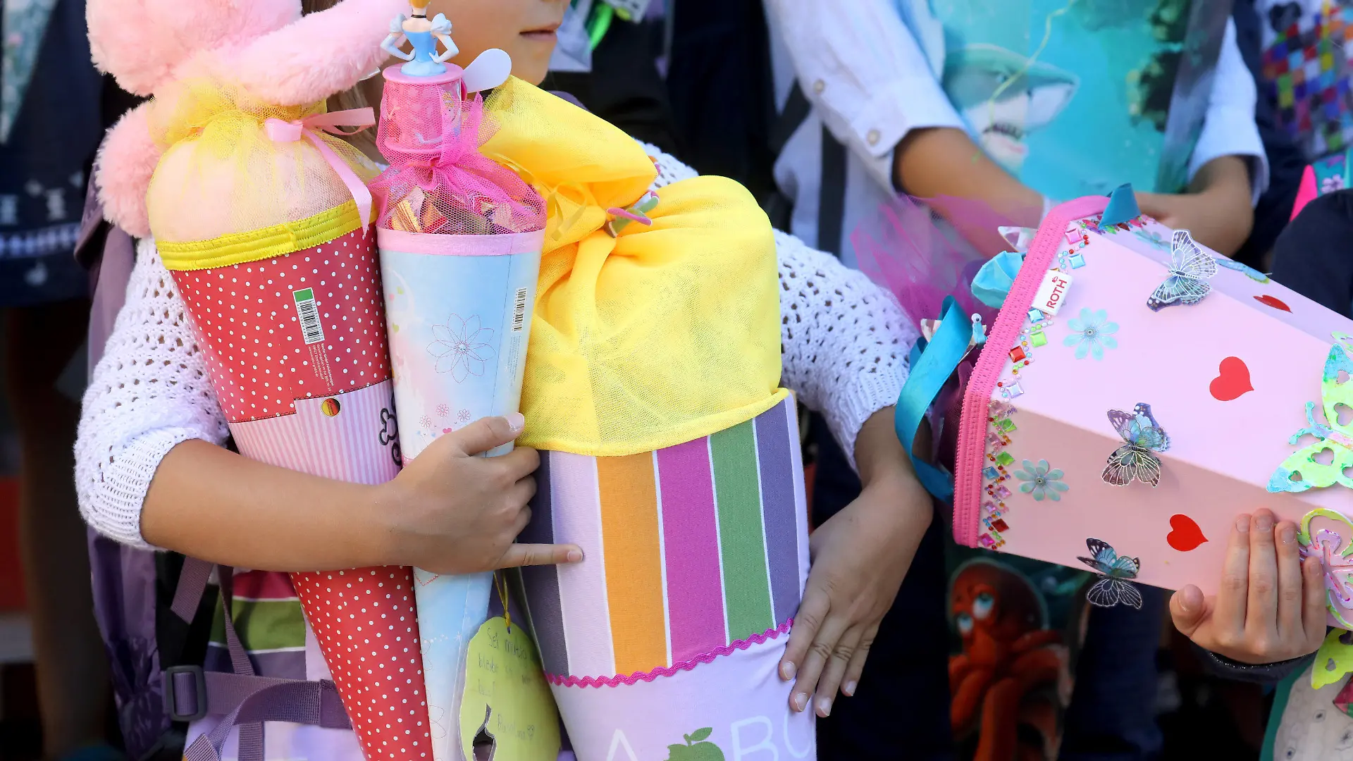 ARCHIV - 18.08.2018, Mecklenburg-Vorpommern, Rostock: Kinder stehen nach ihrer feierlichen Einschulung mit ihren Zuckertüten auf der Treppe. (zu "Fast 34 000 Berliner Erstklässler werden feierlich eingeschult" vom 24.08.2018) Foto: Bernd Wüstneck/dpa +++ dpa-Bildfunk +++