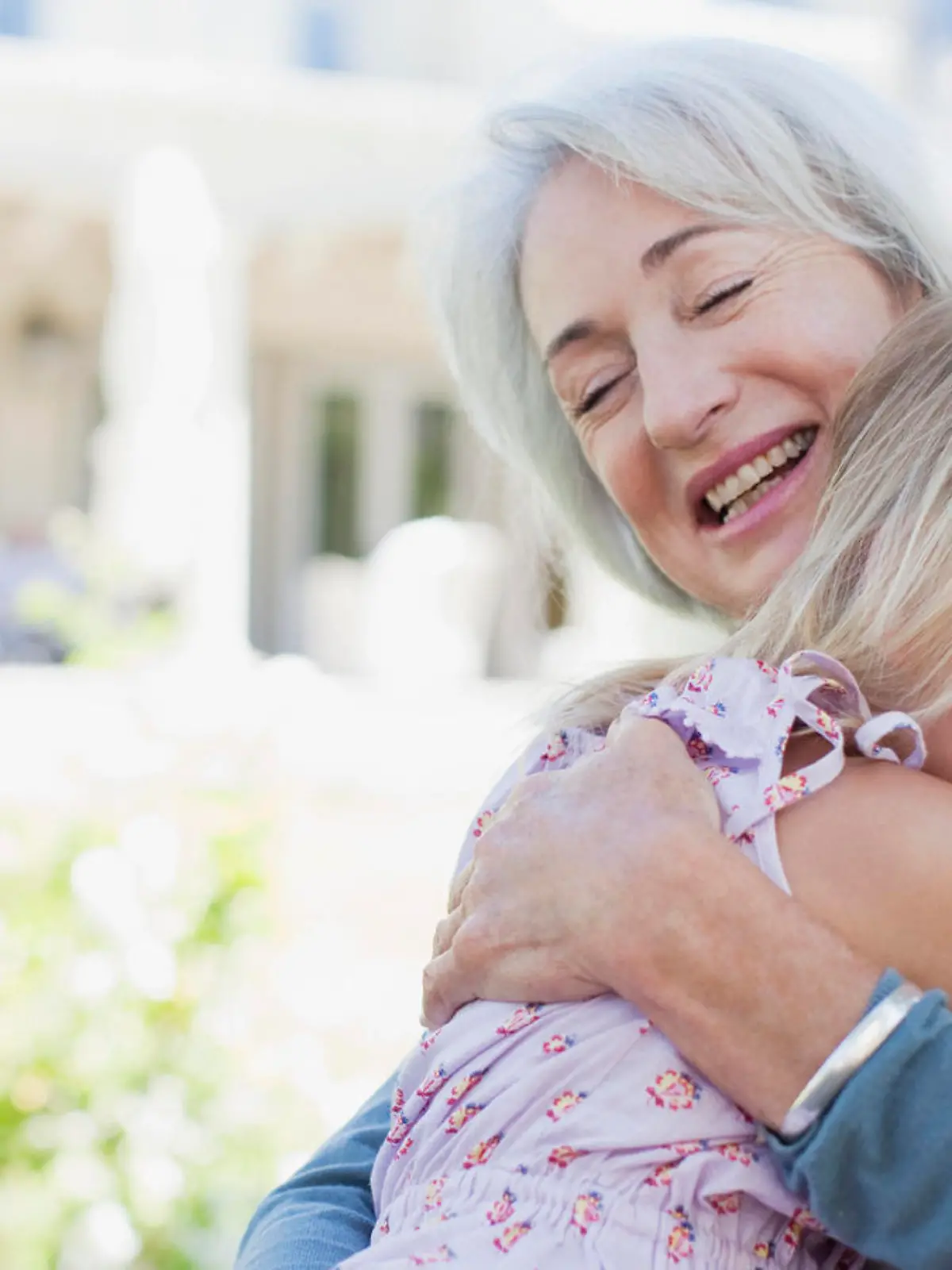 Grandmother and granddaughter hugging in backyard