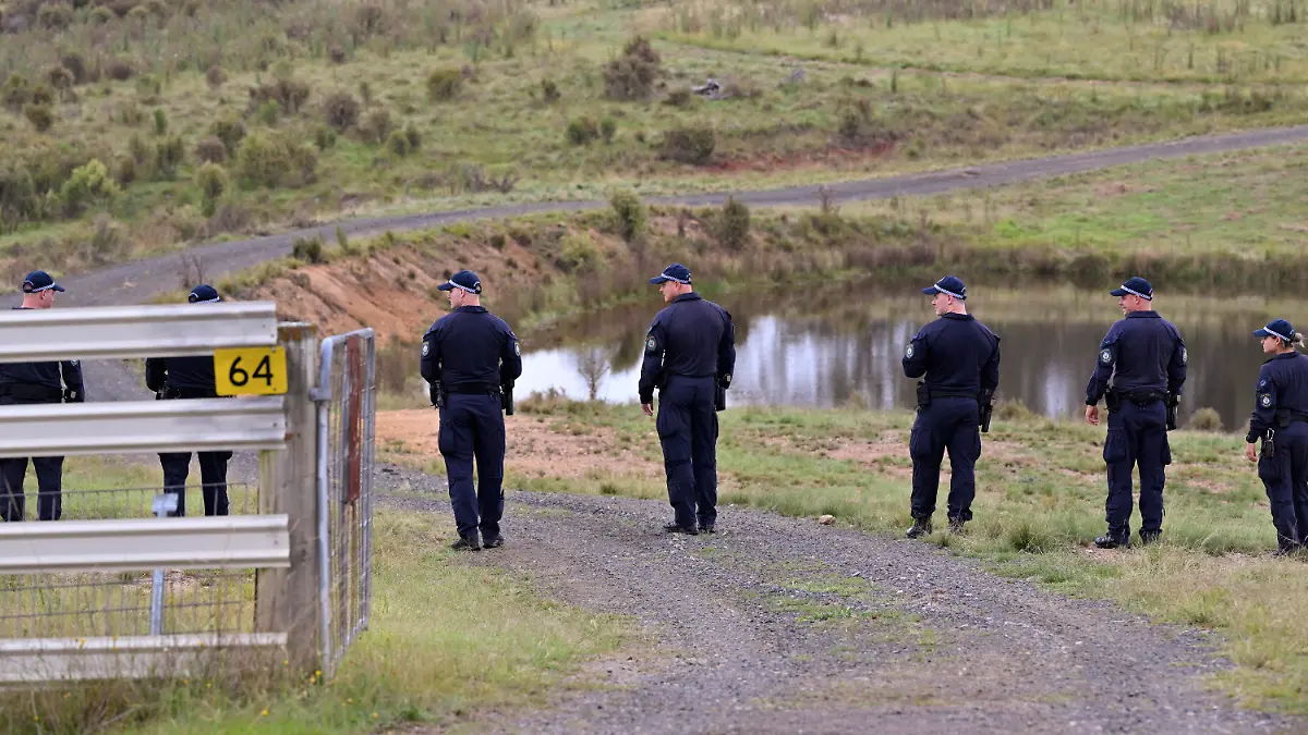 Police conduct a line search near a body of water on a rural property near Bungonia, 170 kilometers (105 miles) southwest of Sydney, Monday, Feb. 26, 2024. Police divers were searching inland waterways on Monday for the bodies of a same-sex couple allegedly shot dead in Sydney a week earlier by a jilted police officer lover with his service pistol.(Mick Tsikas/AAP Image via AP)