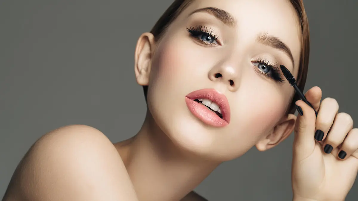 Studio shot of young beautiful girl making eye make-up