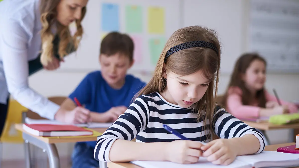 Schoolgirl writing in exercise book in class model released Symbolfoto property released PUBLICATIONxINxGERxSUIxAUTxHUNxONLY ABIF00372