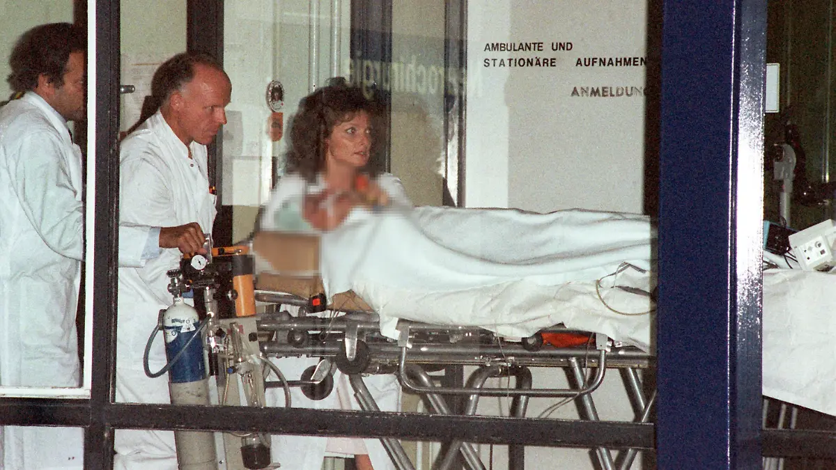 Nach einer mehrstündigen Operation in der Universitätsklinik Freiburg am 15.10.1990 wird Wolfgang Schäuble in einem Krankenbett auf die Intensivstation gebracht. Am 12.10. wurde Innenminister Wolfgang Schäuble bei einer CDU-Wahlkampfveranstaltung in seinem Wahlkreis in Oppenau/Mittelbaden von dem 37jährigen Attentäter Dieter Kaufmann durch zwei Schüsse aus einem Revolver Kaliber 38 schwer verletzt. Eine Kugel drang in die rechte Gesichtshälfte ein, die zweite verletzte die Brustwirbelsäule. Schäubles Leibwächter, der 28jährige Bundesgrenzschutzbeamte Klaus-Dieter Michalsky, erlitt einen Streifschuß am Bauch. Seit dem Attentat ist Innenminister Schäuble auf den Rollstuhl angewiesen.