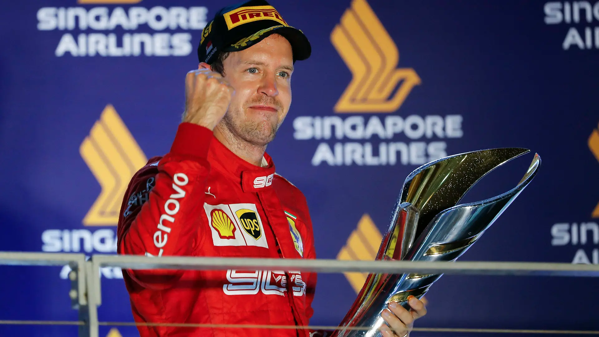 23.09.2019, Singapur: Motorsport: Formel-1-Weltmeisterschaft, Grand Prix von Singapur, Rennen: Sebastian Vettel aus Deutschland vom Team Scuderia Ferrari steht auf dem Podium und freut sich über die Trophäe nach seinem ersten Saisonsieg. Foto: Vincent Thian/AP/dpa +++ dpa-Bildfunk +++