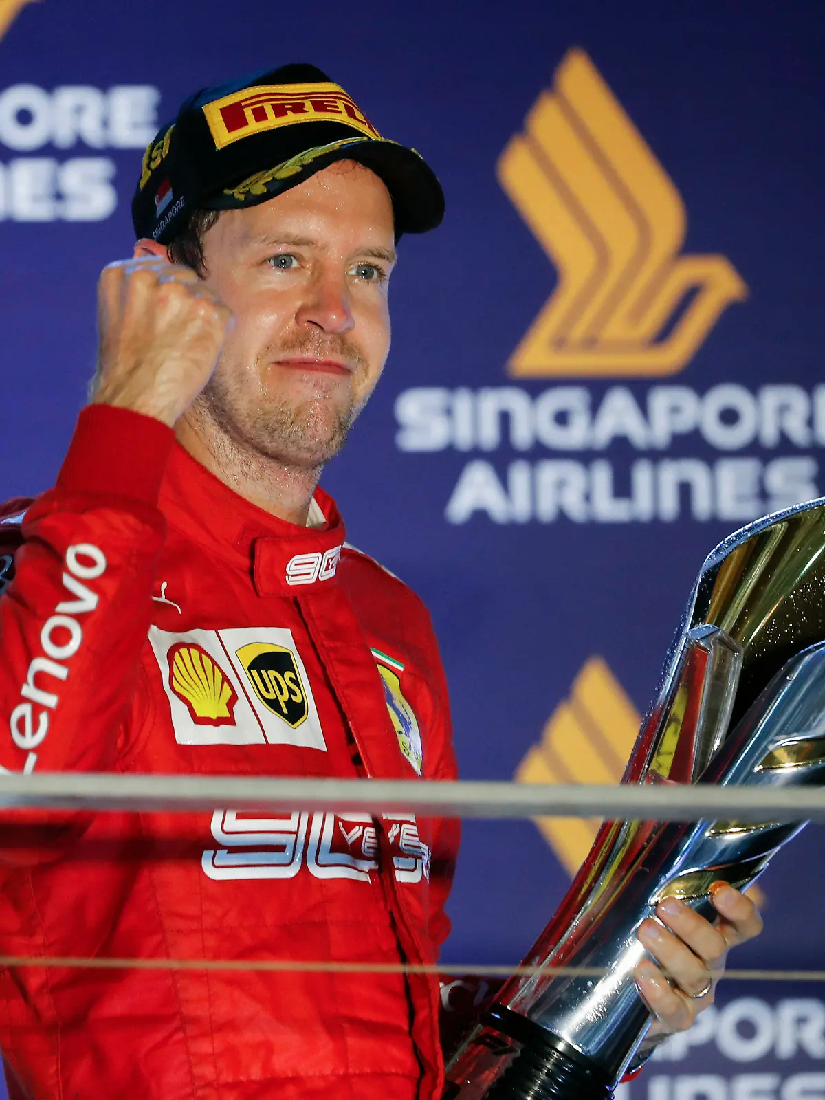 23.09.2019, Singapur: Motorsport: Formel-1-Weltmeisterschaft, Grand Prix von Singapur, Rennen: Sebastian Vettel aus Deutschland vom Team Scuderia Ferrari steht auf dem Podium und freut sich über die Trophäe nach seinem ersten Saisonsieg. Foto: Vincent Thian/AP/dpa +++ dpa-Bildfunk +++