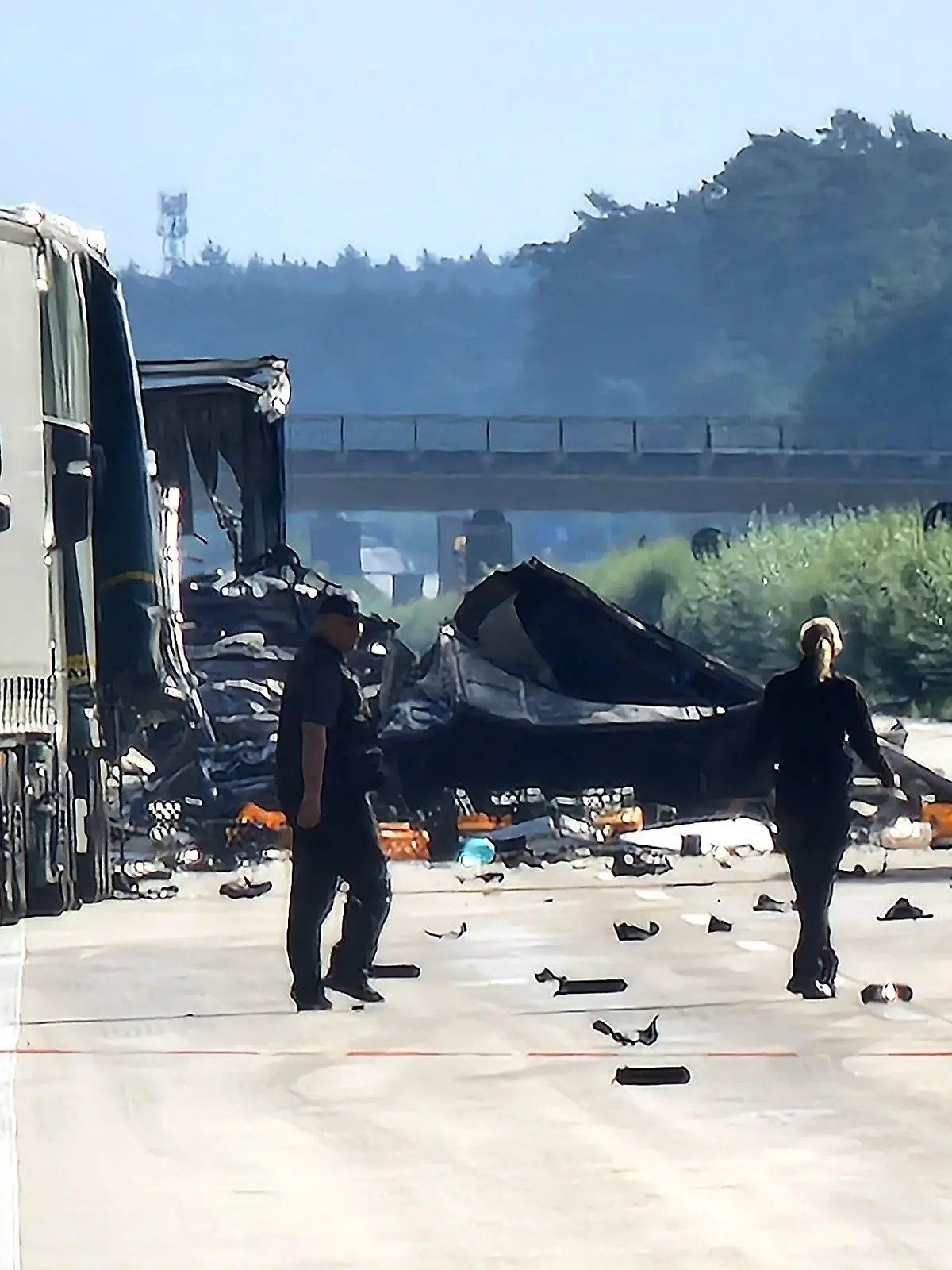 30.08.2023, Sachsen-Anhalt, Theeßen: Mitarbeiter der Polizei gehen auf der Autobahn 2 zwischen Theeßen und Burg zur Unfallstelle. Auch einen Tag nach dem schweren Auffahrunfall mit mindestens zwei Toten besteht an der Unfallstelle weiter Explosionsgefahr. Die Autobahn bleibt gesperrt. Foto: Cevin Dettlaff/dpa-Zentralbild/dpa +++ dpa-Bildfunk +++