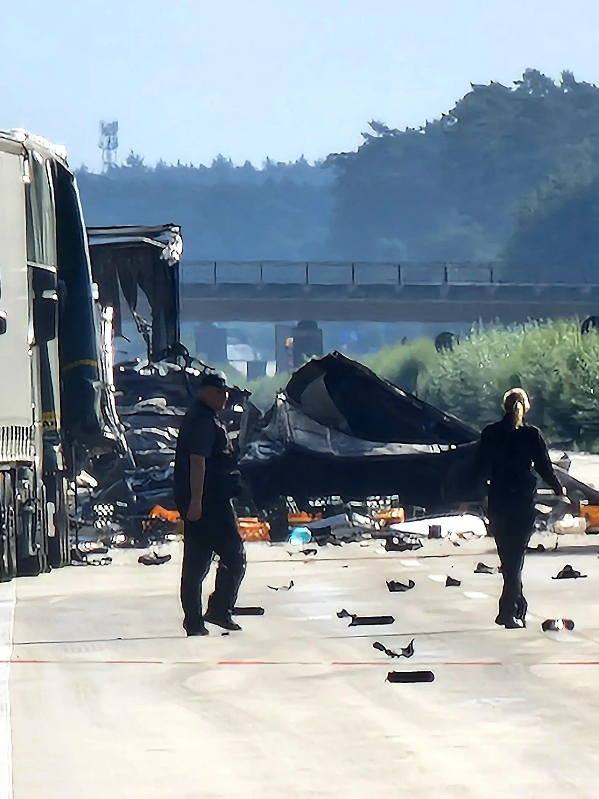 30.08.2023, Sachsen-Anhalt, Theeßen: Mitarbeiter der Polizei gehen auf der Autobahn 2 zwischen Theeßen und Burg zur Unfallstelle. Auch einen Tag nach dem schweren Auffahrunfall mit mindestens zwei Toten besteht an der Unfallstelle weiter Explosionsgefahr. Die Autobahn bleibt gesperrt. Foto: Cevin Dettlaff/dpa-Zentralbild/dpa +++ dpa-Bildfunk +++