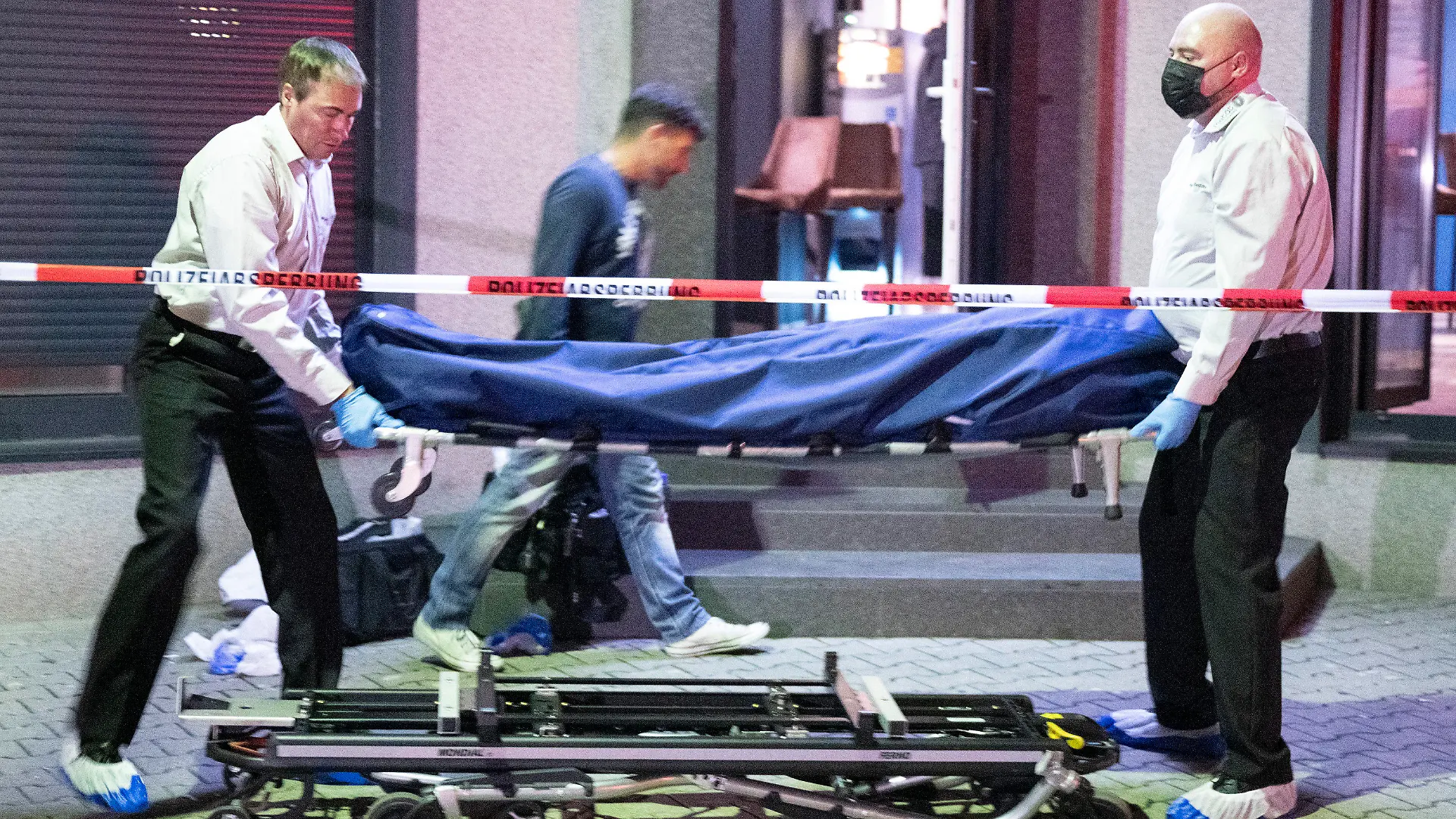 11.09.2022, Hessen, Offenbach am Main: Bestatter tragen die Leiche eines Opfers aus einer Bar in Offenbach. Die Person war durch einen Schuss tödlich verletzt worden, eine weitere Person wurde nach Angaben der Polizei schwer verletzt. Der oder die Täter sind flüchtig. Foto: Boris Roessler/dpa +++ dpa-Bildfunk +++