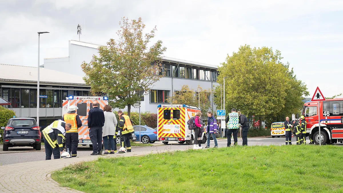 29.09.2022, Hessen, Idstein: Einsatzkräfte der Feuerwehr stehen nach einem Gasaustritt vor der Limesschule. In der Schule wurden durch ein unbekanntes Gas mehrere Schüler und Schülerinnen leicht verletzt und im Krankenhaus behandelt. Foto: Sebastian Gollnow/dpa +++ dpa-Bildfunk +++