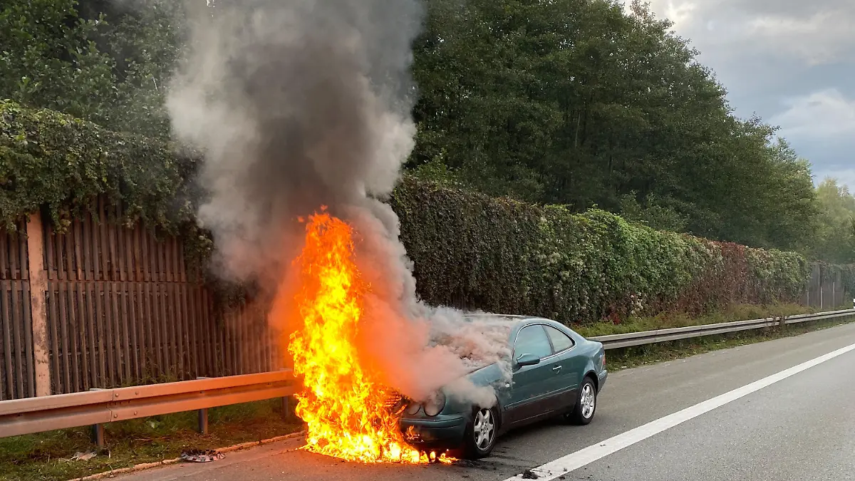 HANDOUT - 29.09.2022, Bayern, Weiden: Ein grünes Auto brennt auf der Autobahn 93. Laut Polizei hatte sich der 20 Jahre alte Fahrer des Wagens zuvor ein Rennen gegen seine Mutter geliefert. (zu dpa «Betrunken und ohne Führerschein - Sohn fährt Autorennen gegen Mutter») Foto: Polizeiinspektion Marktredwitz/dpa - ACHTUNG: Nur zur redaktionellen Verwendung im Zusammenhang mit der aktuellen Berichterstattung und nur mit vollständiger Nennung des vorstehenden Credits +++ dpa-Bildfunk +++