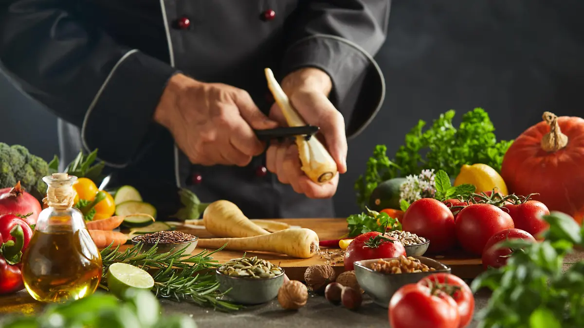  Adult chef peeling carrot above cutting board PUBLICATIONxINxGERxSUIxAUTxONLY Copyright: xfoodandmorex Panthermedia25923562