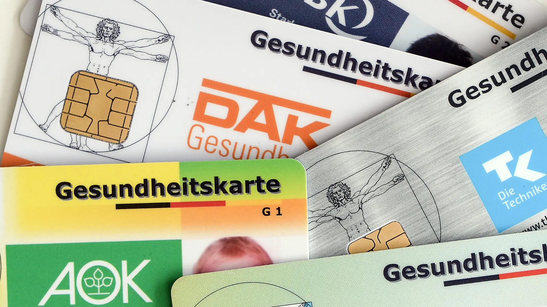 ARCHIV - 17.04.2018, Berlin: Gesundheitskarten verschiedener Krankenkassen liegen auf einem Tisch. Die Mitglieder der gesetzlichen Krankenkassen sollen dauerhaft davor geschützt werden, steigende Gesundheitskosten allein tragen zu müssen. Foto: Jens Kalaene/dpa-Zentralbild/dpa +++ dpa-Bildfunk +++