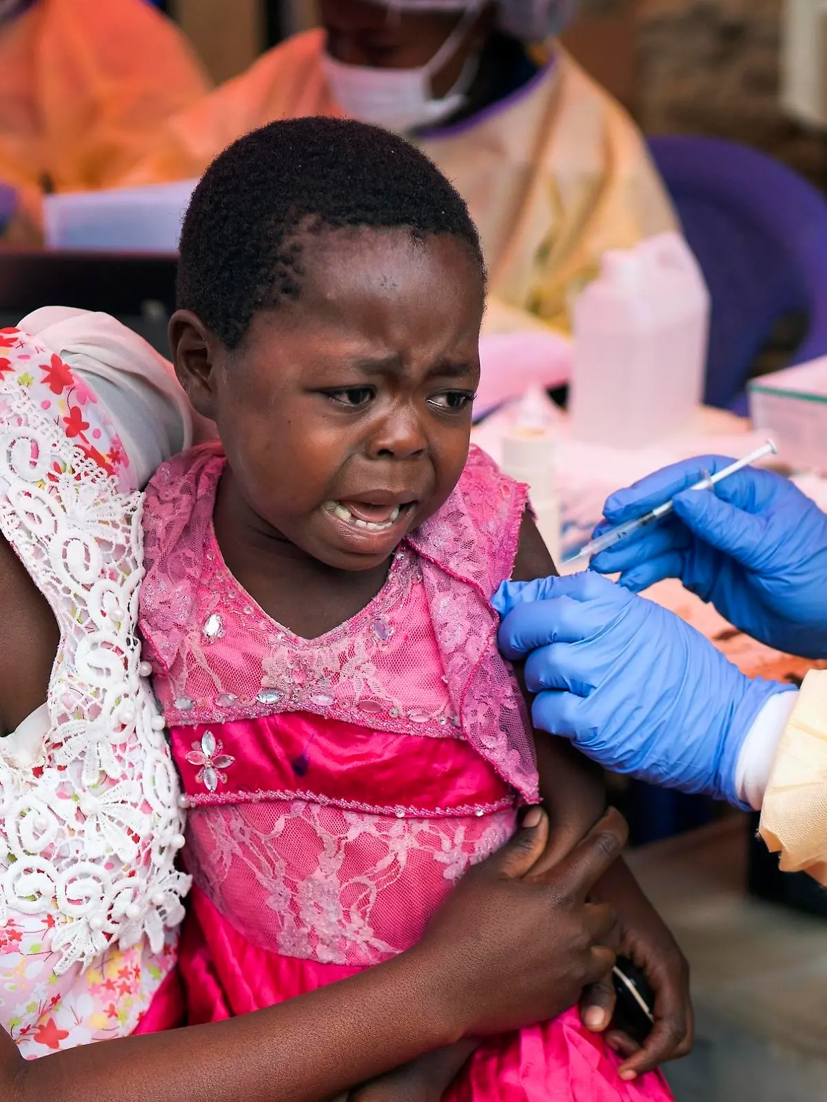 13.07.2019, Kongo, Beni: Dieses am 17.07.2019 zur Verfügung gestellte Bild vom 13.07.2019 zeigt einen Helfer, der einem Mädchen einen Ebola-Impfstoff spritzt. Kongos Gesundheitsministerium hatte Anfang August 2018 offiziell einen neuen Ebola-Ausbruch im Osten des Landes bestätigt. Wegen eines Falls in der Millionenstadt Goma will die Weltgesundheitsorganisation (WHO) nun zum vierten Mal prüfen, ob eine «Notlage von internationaler Tragweite» ausgerufen werden soll. Foto: Jerome Delay/AP/dpa +++ dpa-Bildfunk +++