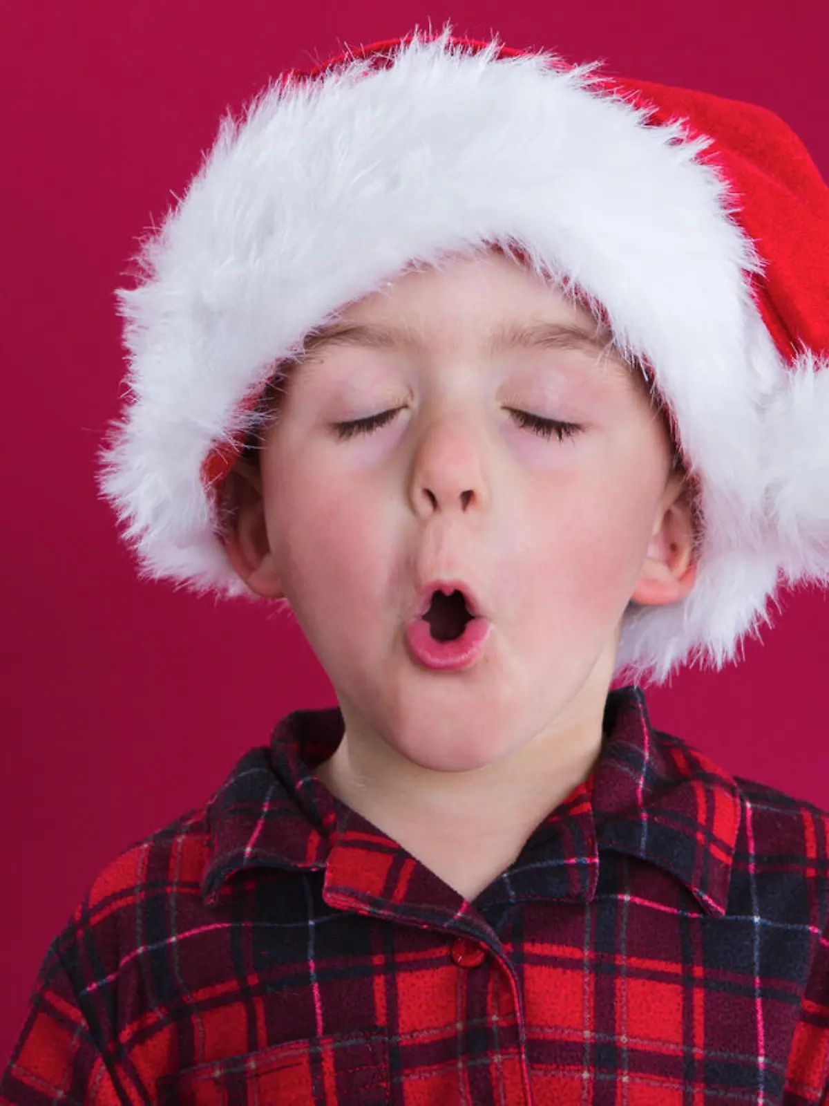 Junge singt, mit Weihnachtsmütze