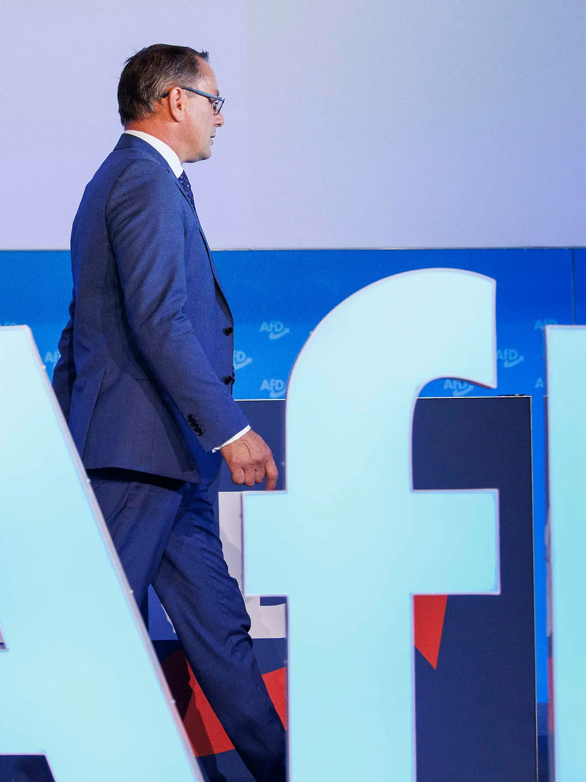 30.07.2023, Sachsen-Anhalt, Magdeburg: Tino Chrupalla, AfD-Bundesvorsitzender und Fraktionsvorsitzender der AfD, geht hinter dem AfD-Parteilogo vor der Fortsetzung der Europawahlversammlung in der Messe Magdeburg. Foto: Carsten Koall/dpa +++ dpa-Bildfunk +++