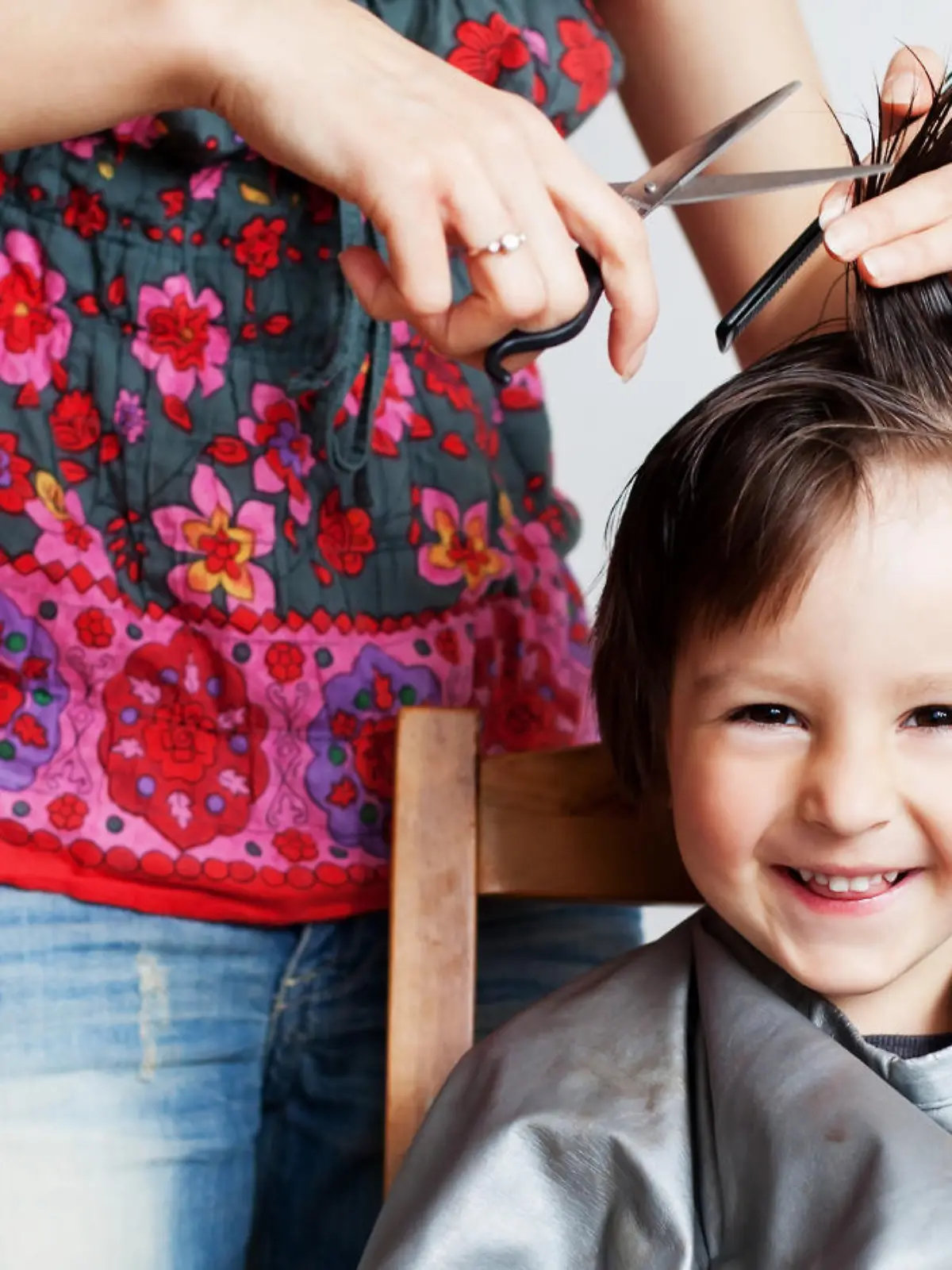 Cute little boy, having haircut, smiling happily, white background