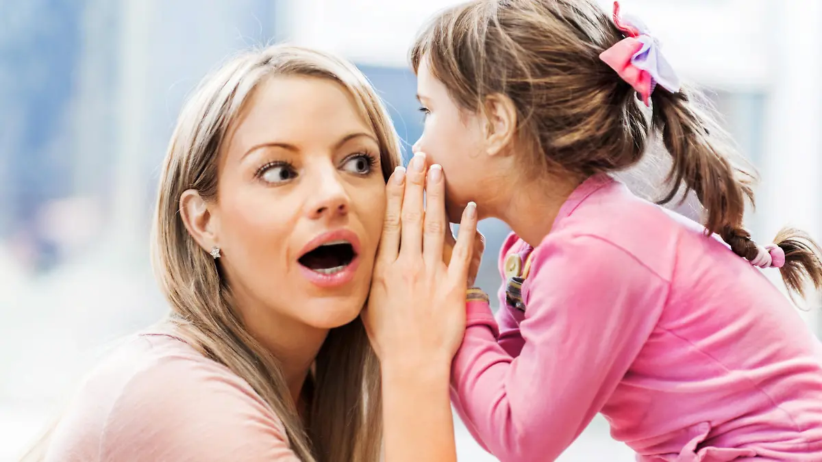 Beautiful little girl whispering a secret to her mother.