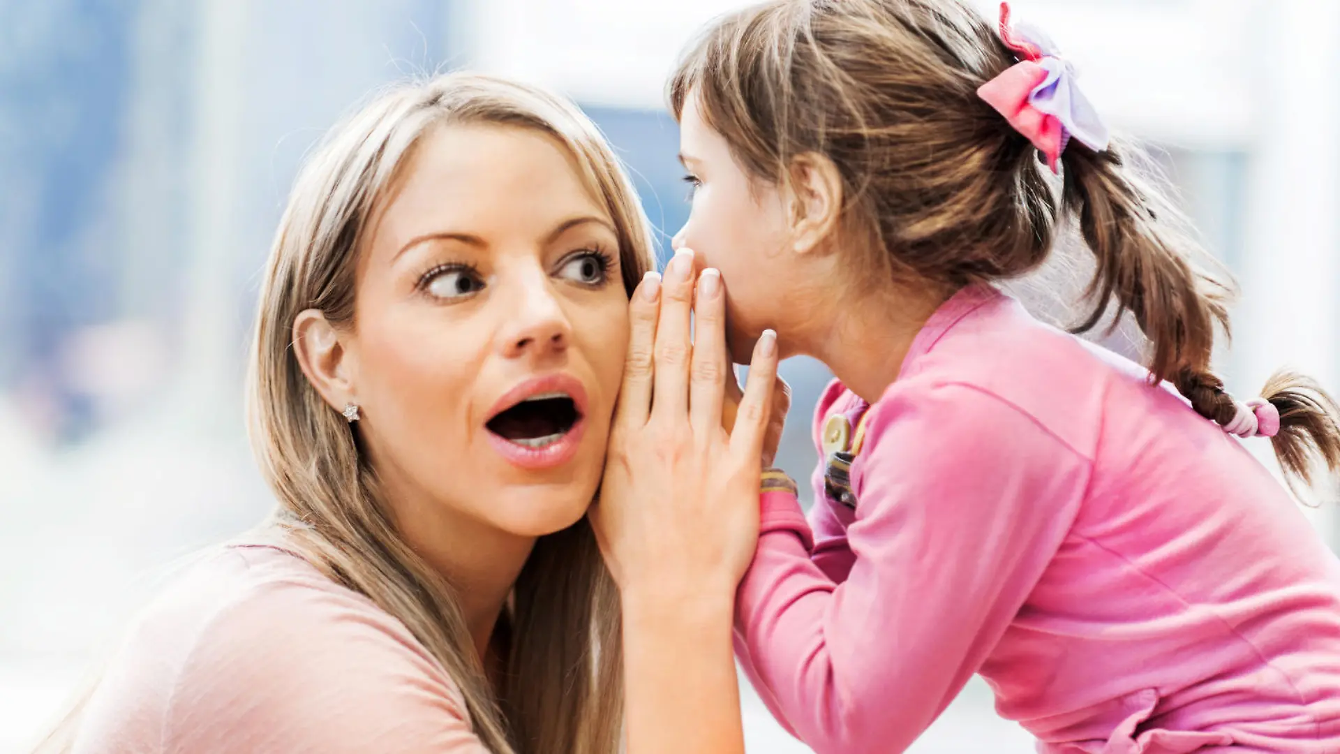 Beautiful little girl whispering a secret to her mother.