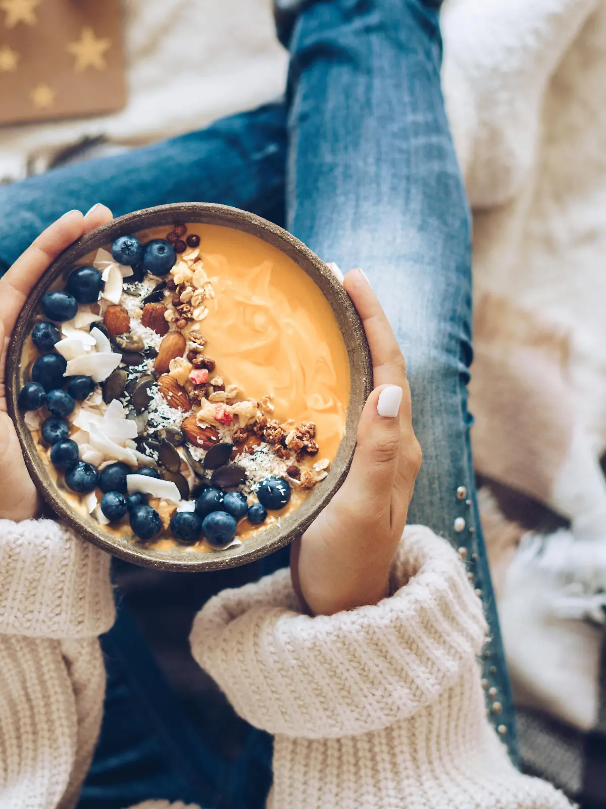 Pumpkin pie smoothie bowl topped with berries, granola, and coconut flakes
