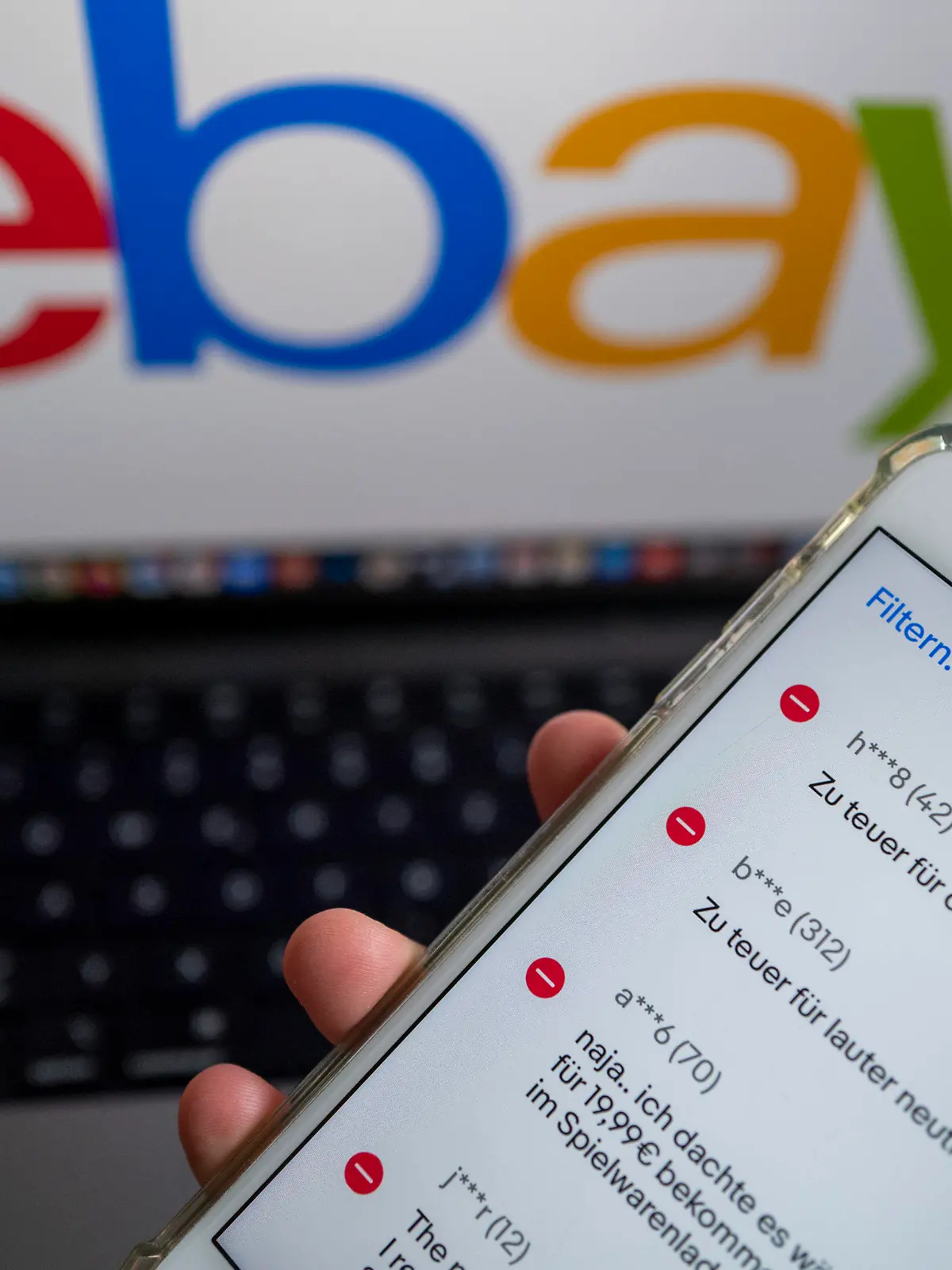 ILLUSTRATION - 26.09.2022, Berlin: ILLUSTRATION - Auf einem Smartphone in der Ebay-App werden negative Bewertungen eines Verkäufers angezeigt, während im Hintergrund das Logo der Verkaufsplattform Ebay zu sehen ist. Der Bundesgerichtshof prüft derzeit, wann Ebay-Verkäufer Anspruch auf Entfernung von negativen Bewertungen haben. Foto: Monika Skolimowska/dpa +++ dpa-Bildfunk +++