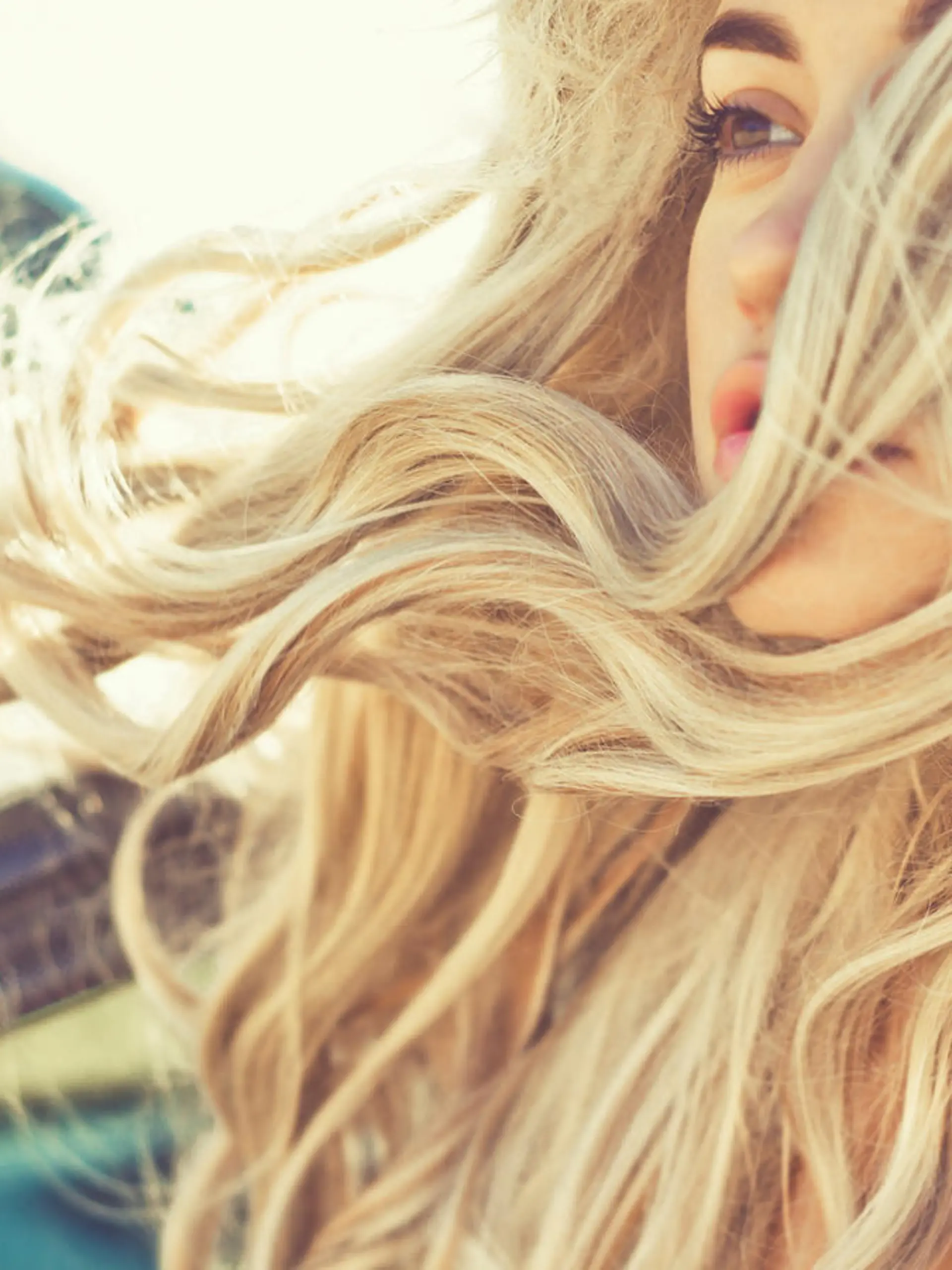 Atmospheric outdoors fashion portrait of beautiful blonde in car on the beach