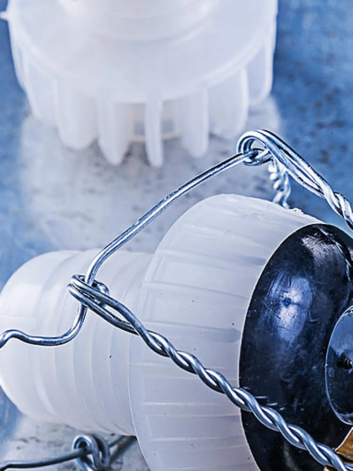 Plastic cork stoppers with twisted wire on metallic background.