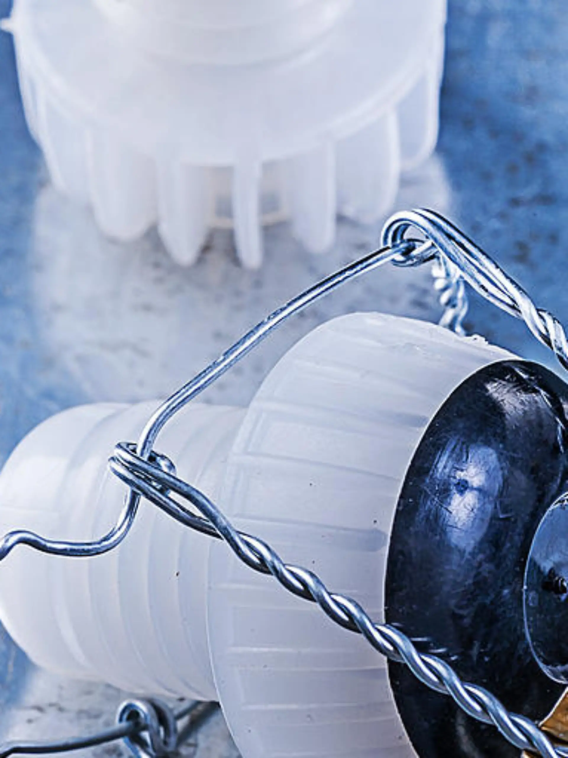 Plastic cork stoppers with twisted wire on metallic background.