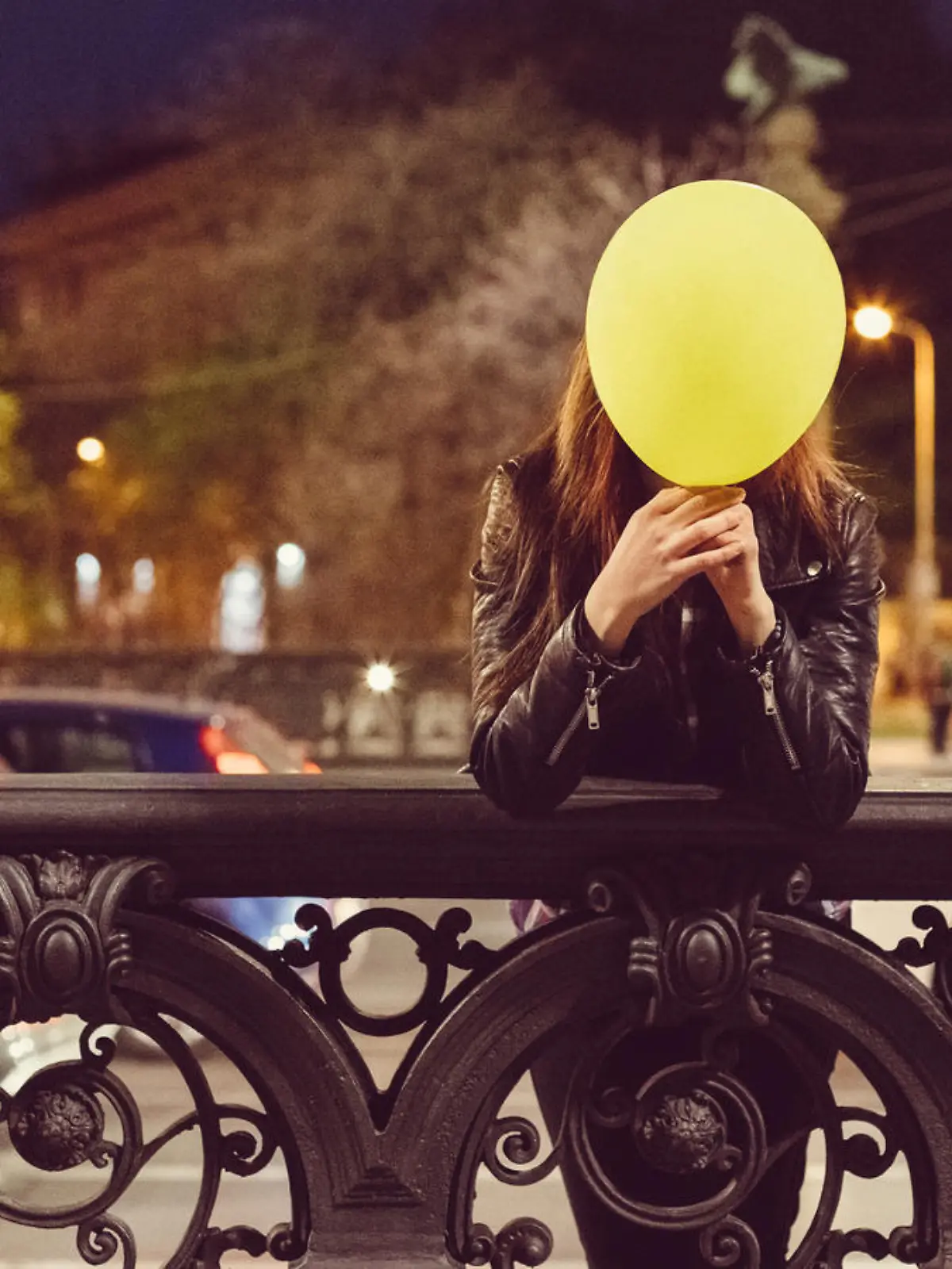 Young girl hiding her face behind a balloon