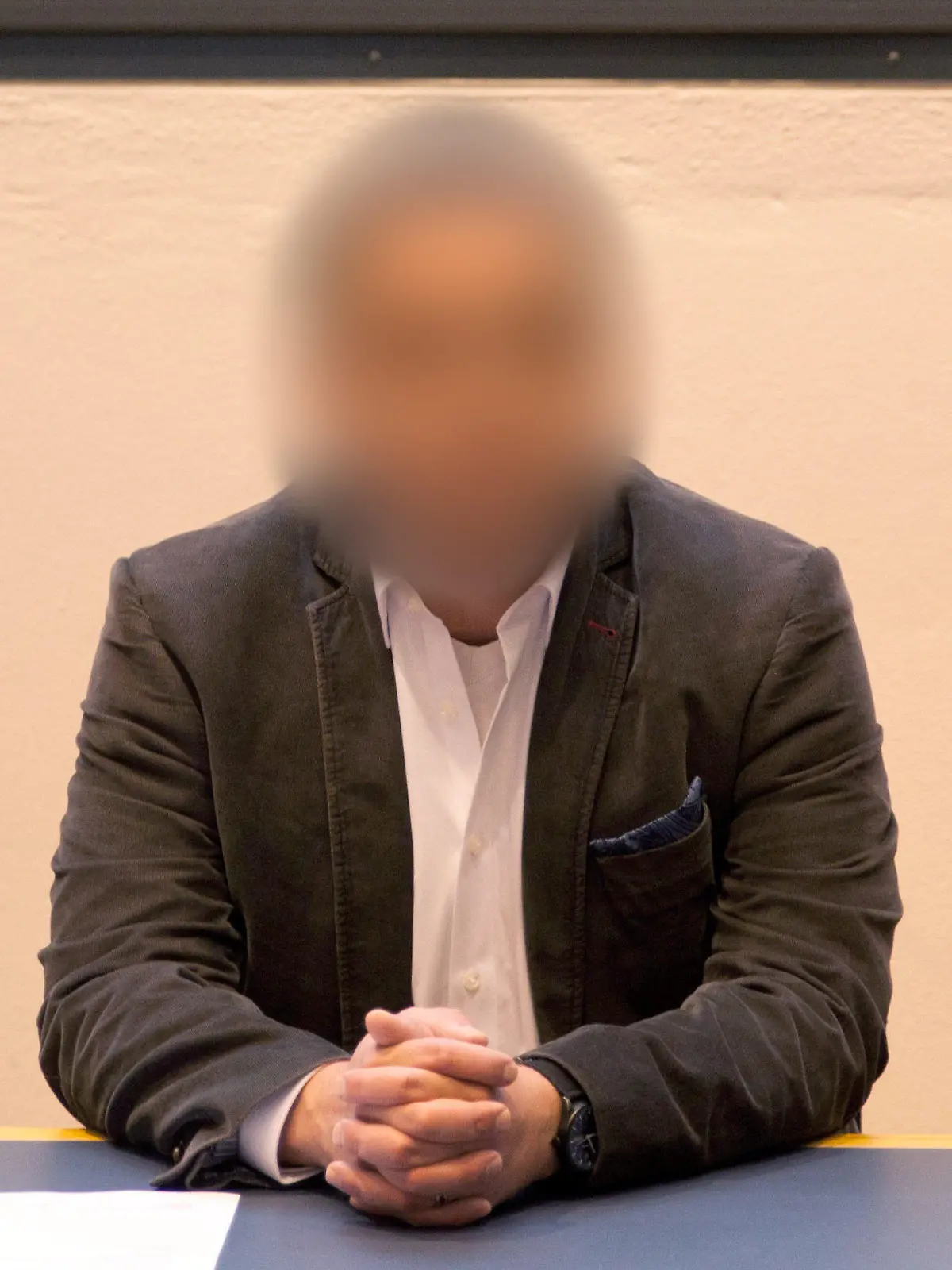 28.09.2018, Sachsen-Anhalt, Magdeburg: Der angeklagte Arzt sitzt vor Prozessbeginn auf der Anklagebank. Der Angeklagte muss sich unter anderem wegen Vergewaltigung mit Todesfolge verantworten. Dem 42 Jahre alte Mediziner aus Halberstadt werden seit September 2015 insgesamt zehn Taten zur Last gelegt. Foto: Johannes Stein/dpa-Zentralbild/dpa +++ dpa-Bildfunk +++