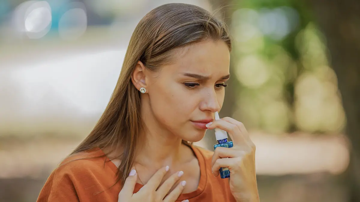 A Woman of Caucasian Ethnicity is Using Nasal Spray Due to the Problems with Nose and Breathing in the Public Park.