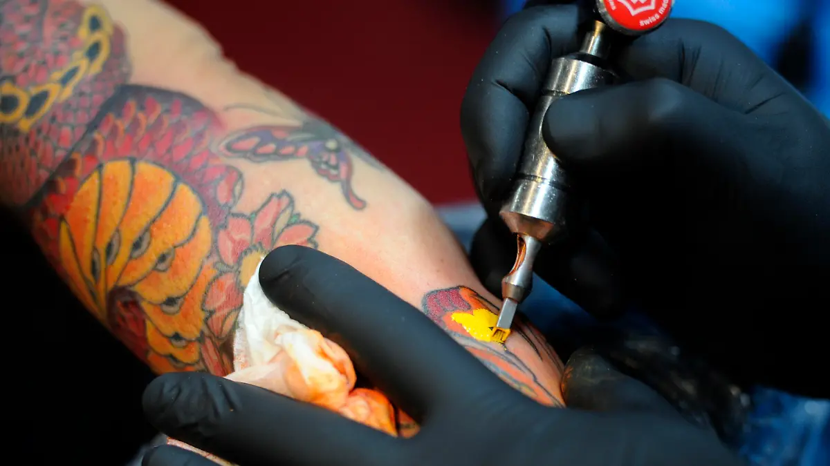 ARCHIV - Ein Tätowierer sticht am 14.06.2013 auf der "Tattoo & Piercing Convention" in Dortmund (Nordrhein-Westfalen) ein Tattoo. Tattoos am Hals, an den Händen und im Gesicht sind für rheinland-pfälzische Polizisten schon seit langem tabu. Foto: Marius Becker/dpa (zu dpa "Tattoo-Regeln gelten für rheinland-pfälzische Polizei seit langem" vom 27.10.2013) +++(c) dpa - Bildfunk+++