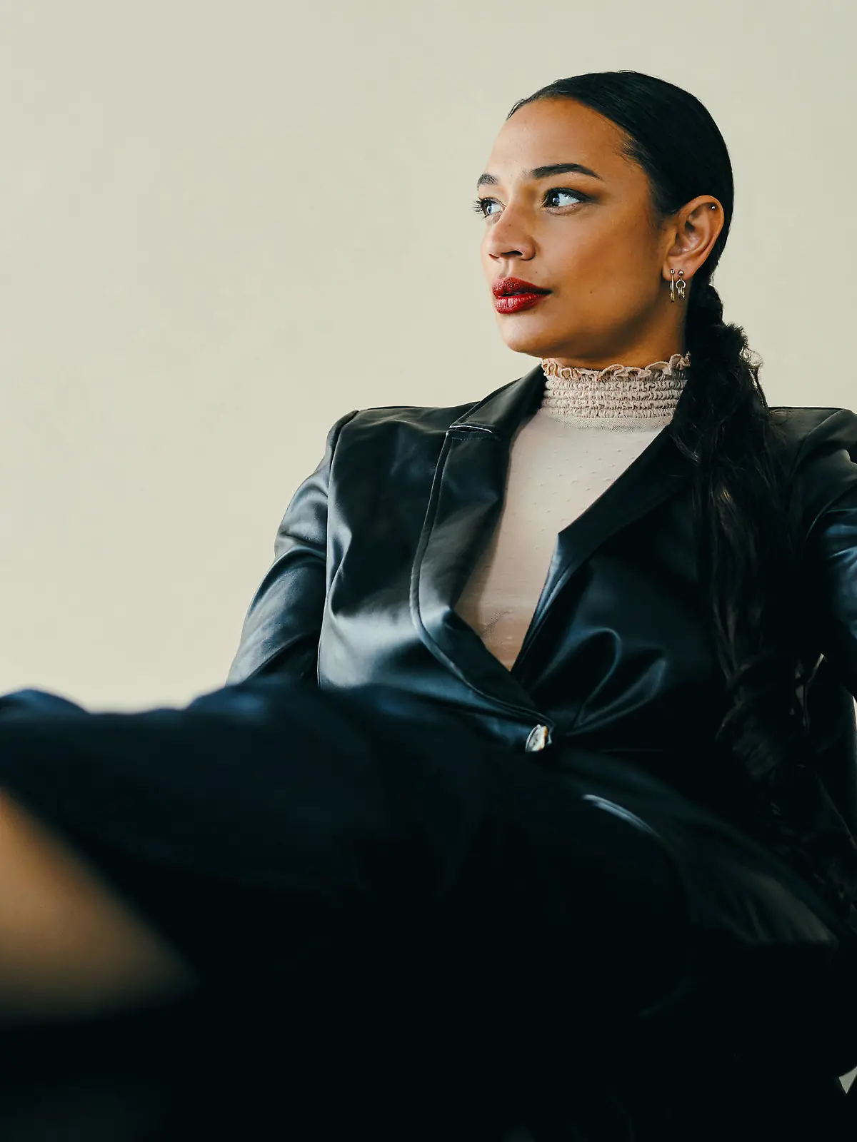 Studio shot of a beautiful young woman sitting with her feet up on a table against a brown background