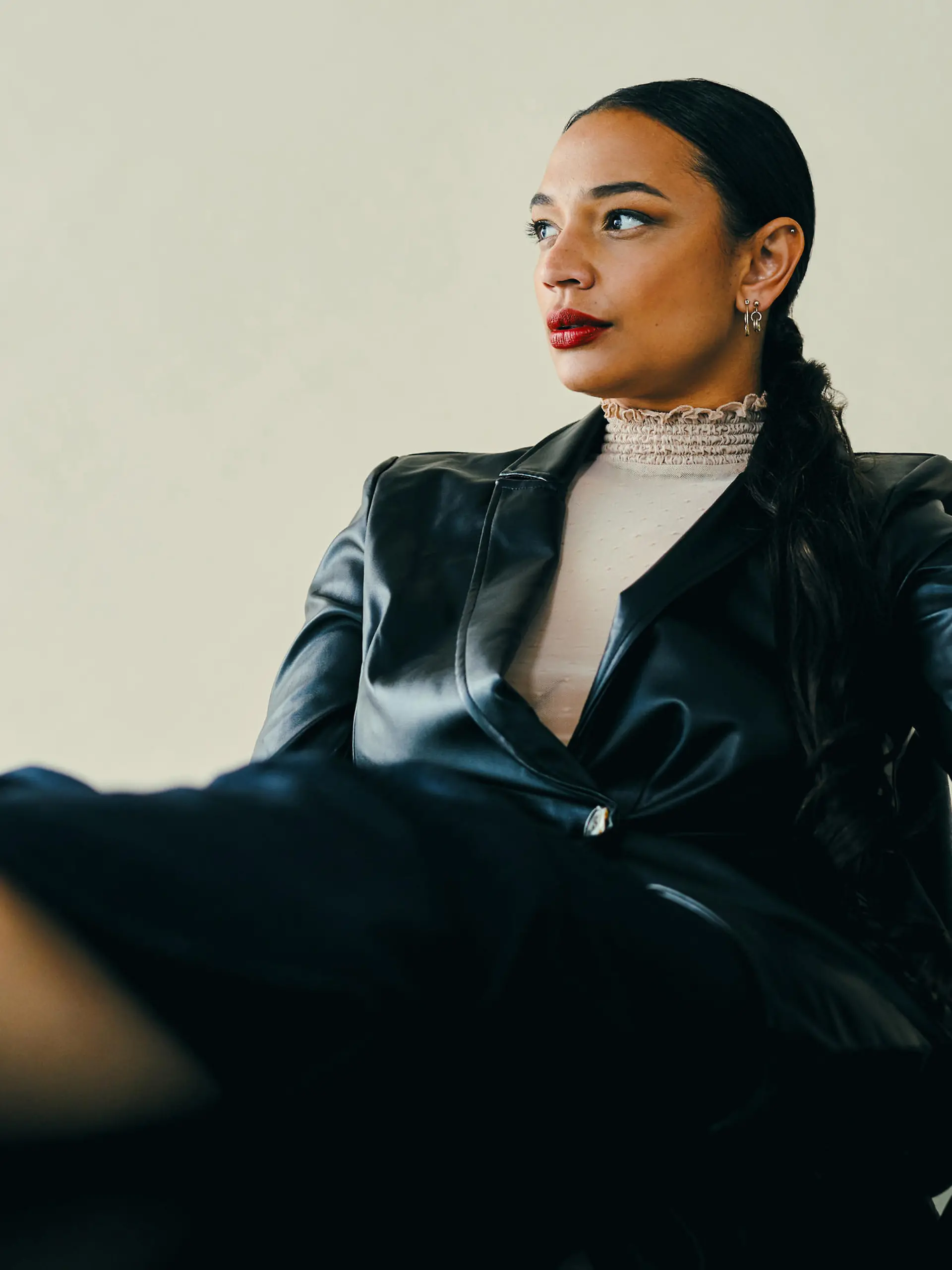 Studio shot of a beautiful young woman sitting with her feet up on a table against a brown background