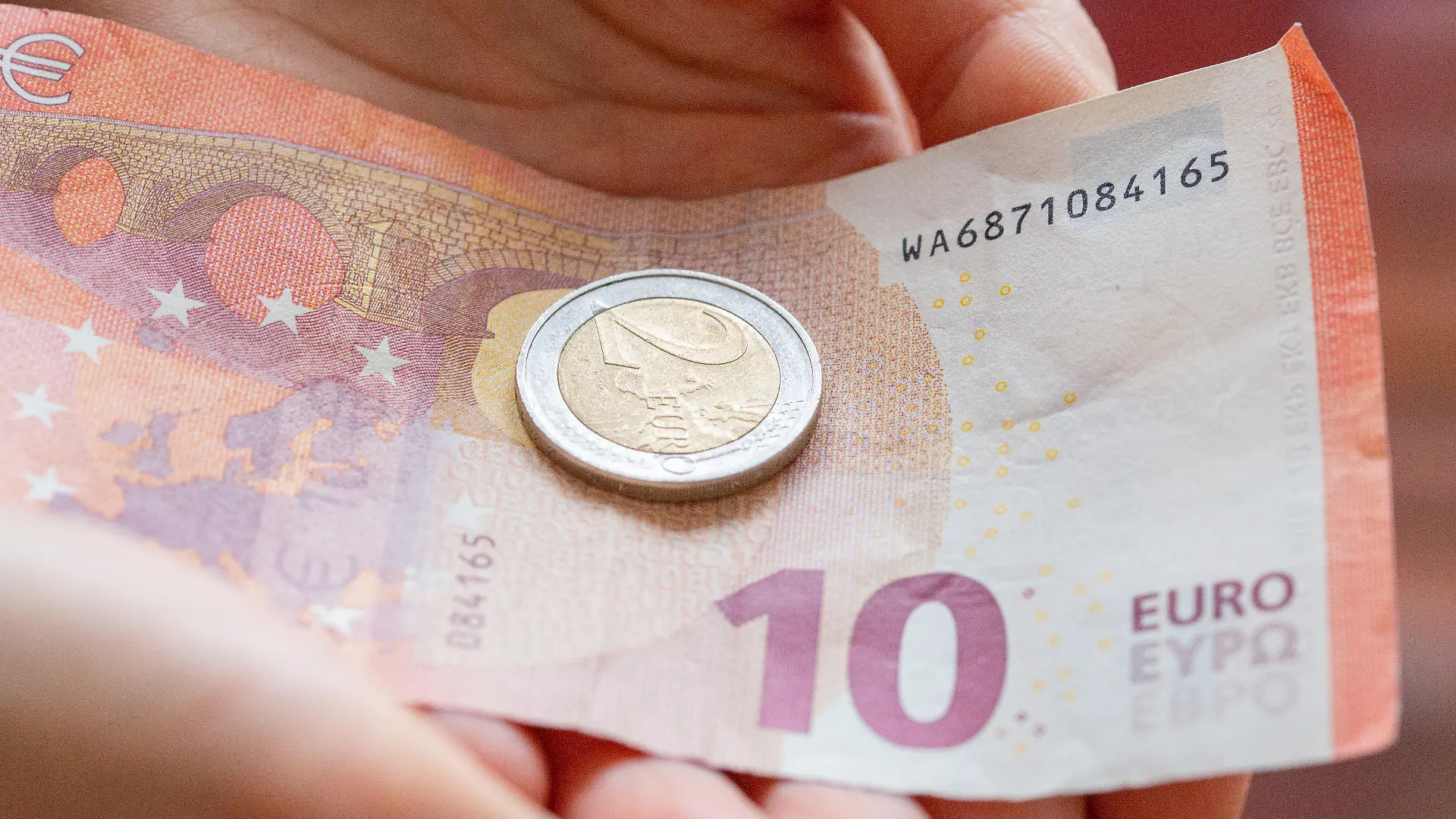 ARCHIV - 10.02.2022, Berlin: Eine Person hält 12 Euro in der Hand. Der gesetzliche Mindestlohn steigt zum 1. Oktober auf 12 Euro je Stunde von zuvor 10,45 Euro. Seit 2015 ist der Mindestlohn damit um mehr als 40 Prozent gestiegen. Foto: Fernando Gutierrez-Juarez/dpa-Zentralbild/dpa +++ dpa-Bildfunk +++