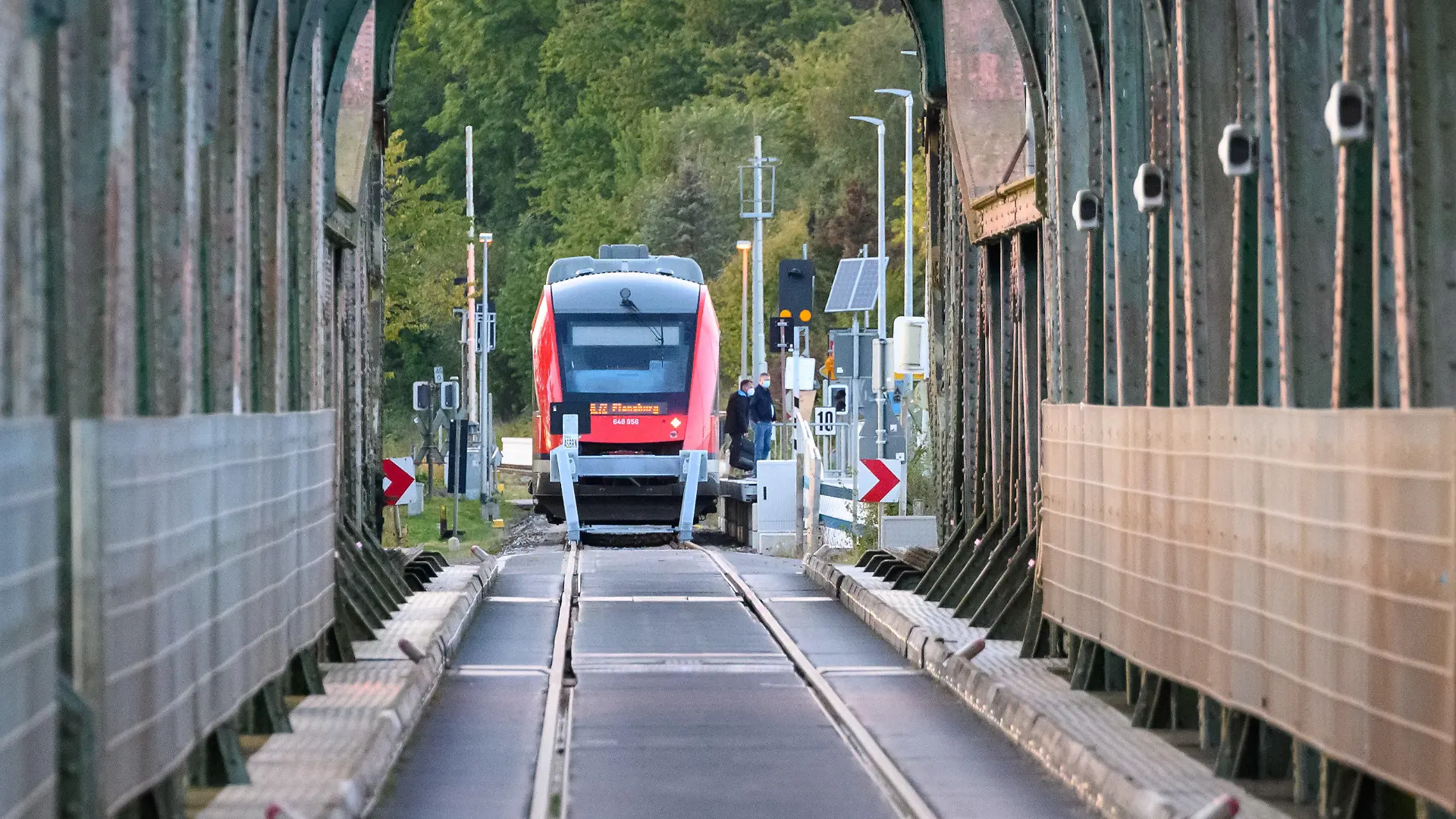 PRODUKTION - 25.09.2022, Schleswig-Holstein, Boren: Ein Regionalzug wartet am Behelfsbahnhof vor der Lindaunisbrücke auf Fahrgäste. Normalerweise fahren Züge über die Schleibrücke bei Lindaunis. Seit Mitte September aber heißt es für Fahrgäste: Austeigen und zu Fuß die Schlei passieren. Wegen Bauarbeiten ist die Brücke über die Schlei bei Lindaunis für Autos und Züge gesperrt. Foto: Jonas Walzberg/dpa +++ dpa-Bildfunk +++