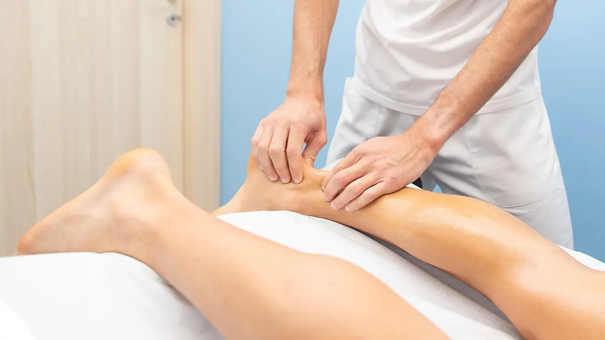 Gesundheitslexikon: Ein Physiotherapeut während einer Behandlung der Achillessehne