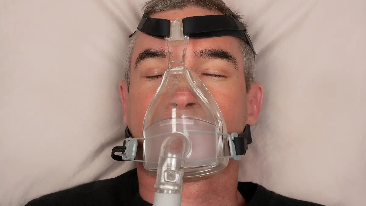 Man with sleep apnea and CPAP machine