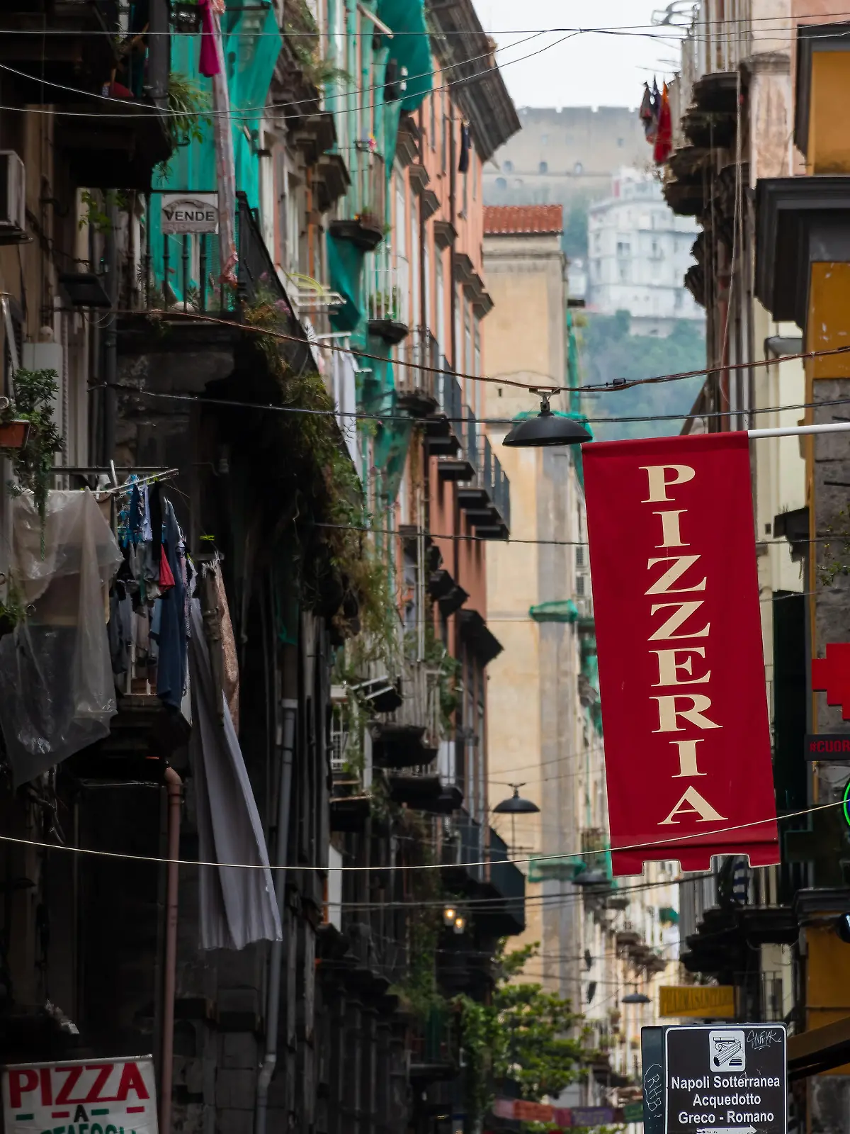 Naples, Italy. May 27, 2022. Red pizzeria sign above the street in Naples, Italy