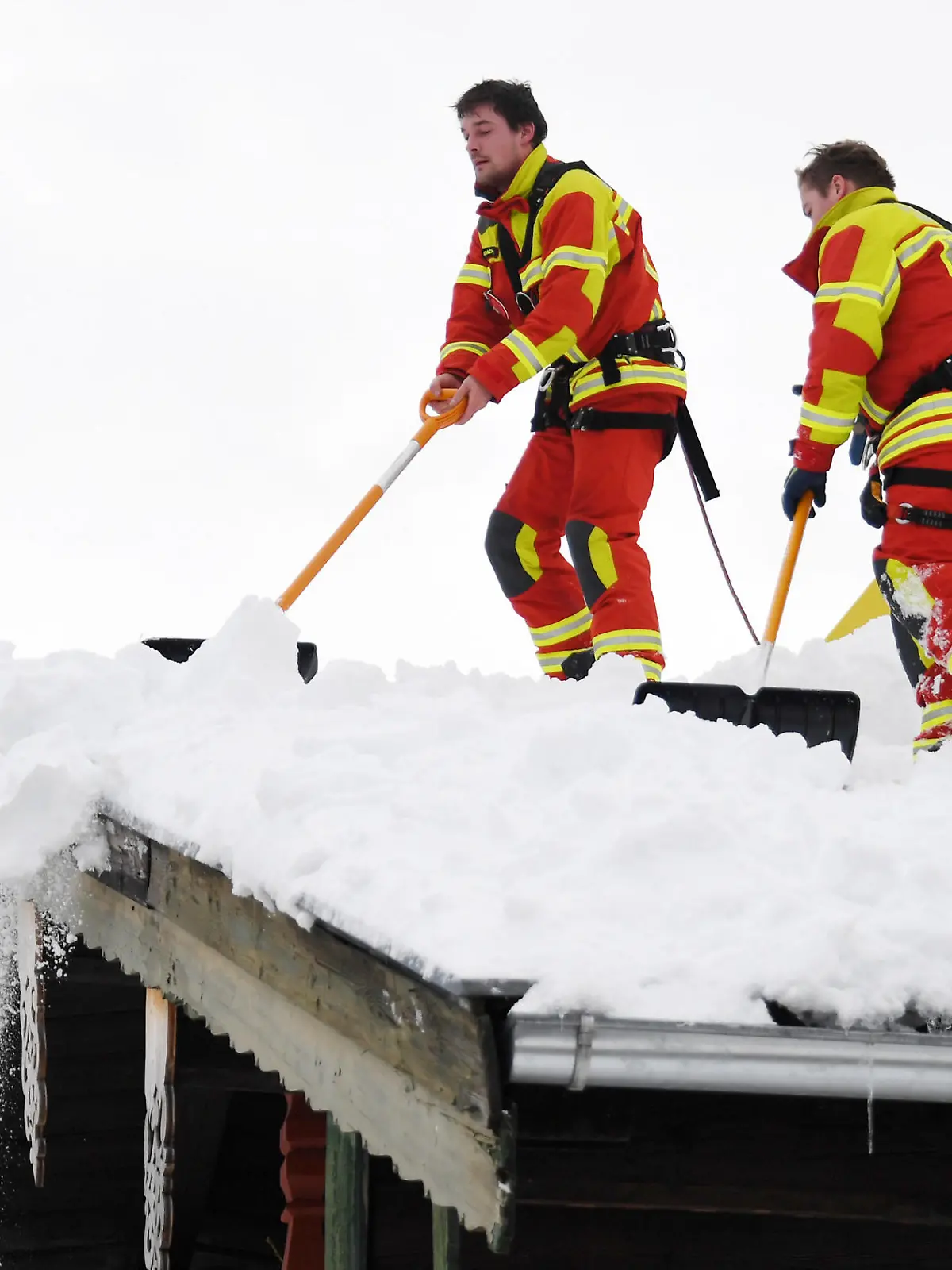 11.01.2019, Bayern, Inzell: Feuerwehrleute räumen den Schnee vom Dach eines Hauses. Die heftigen Schneefälle der vergangenen Tage halten in Südbayern weiter die Einsatzkräfte in Atem und neuer Schnee ist bereits im Anmarsch. Mehr als 1000 Helfer sind nach Behördenangaben in den südlichen Landkreisen von Oberbayern im Einsatz gewesen. Foto: Tobias Hase/dpa +++ dpa-Bildfunk +++