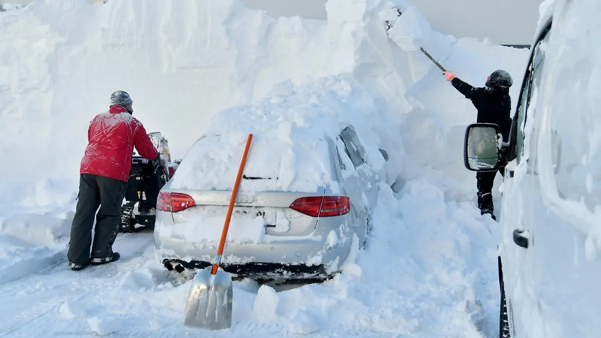 11.01.2019, Österreich, Obertauern: Zwei Männer befreien ein eingeschneites Auto von den Schneemengen. In weiten Teilen Österreichs sind in den letzten Tagen erhebliche Mengen an Schnee gefallen. Foto: Barbara Gindl/APA/dpa +++ dpa-Bildfunk +++