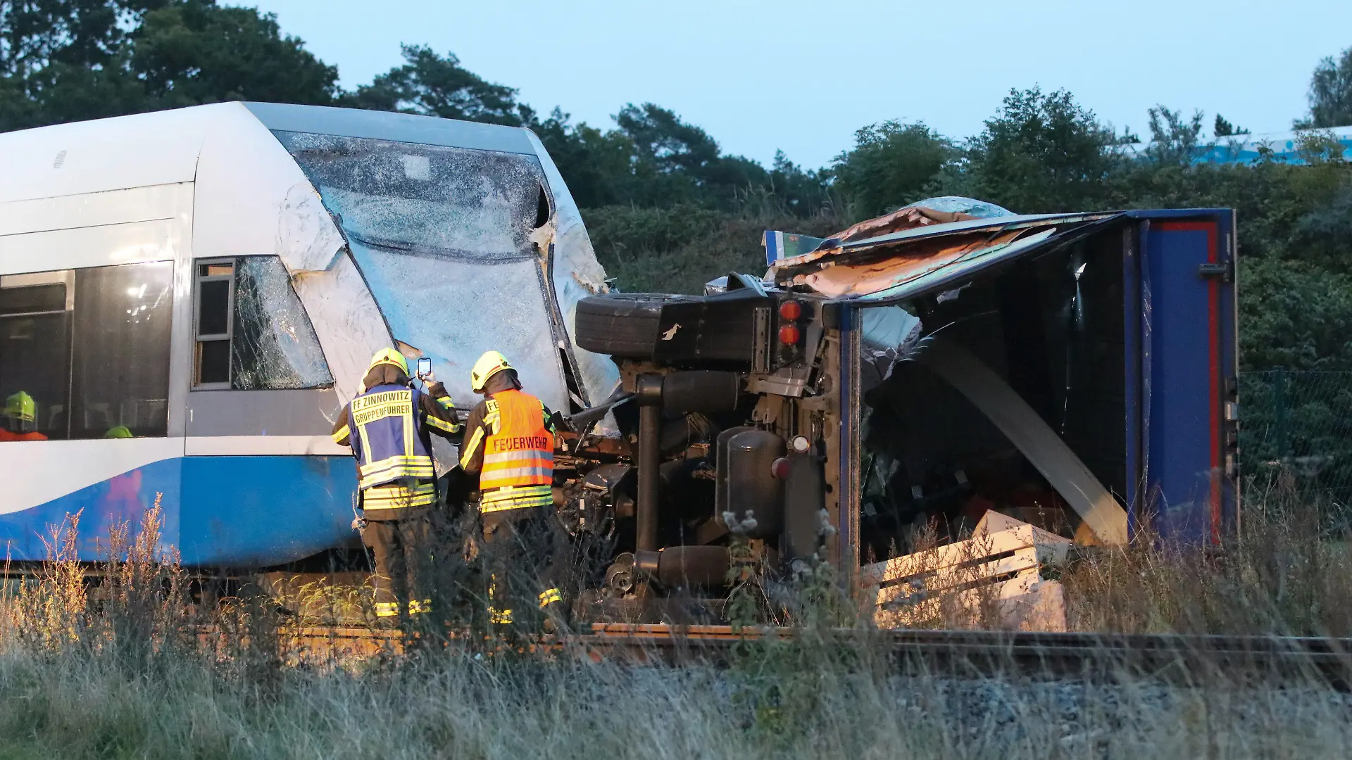 27.09.2022, Mecklenburg-Vorpommern, Koserow: Ein Laster liegt nach einem Unfall auf der Bahnstrecke vor einem Zug. Bei dem Zusammenstoß  sind am Dienstagmorgen auf der Insel Usedom mehrere Reisende und der Zugführer verletzt worden. Wie ein Sprecher der Bundespolizei sagte, ereignete sich der Unfall am frühen Morgen an einem Bahnübergang auf der Bundesstraße 111 zwischen Koserow und Kölpinsee (Vorpommern-Greifswald). Im Zug sollen etwa 15 Passagiere und Bahnmitarbeiter gewesen sein. Insgesamt soll es sieben Leichtverletzte und zwei Schwerverletzte geben. Ein Großaufgebot an Rettungskräften sei im Einsatz. Foto: Tilo Wallrodt/dpa +++ dpa-Bildfunk +++