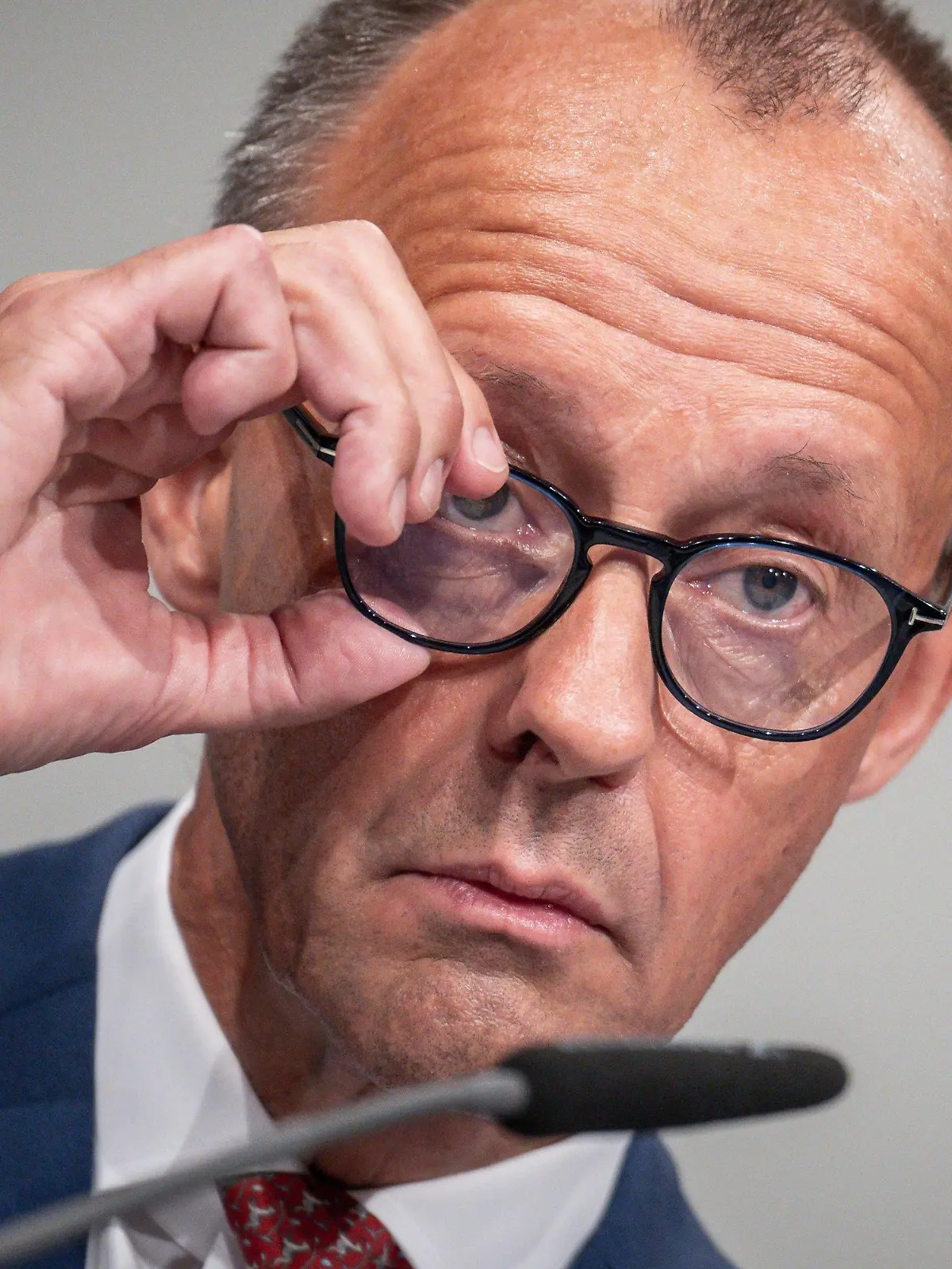 ARCHIV - 09.09.2022, Niedersachsen, Hannover: Friedrich Merz, CDU Bundesvorsitzender, rückt sich beim CDU Bundesparteitag die Brille zurecht. Der CDU-Chef hat einen «Sozialtourismus» von ukrainischen Flüchtlingen nach Deutschland beklagt. Er sagte Bild TV in einem am Montagabend gesendeten Interview: «Wir erleben mittlerweile einen Sozialtourismus dieser Flüchtlinge: nach Deutschland, zurück in die Ukraine, nach Deutschland, zurück in die Ukraine.» Der Hintergrund laut Merz: Anfangs hatten Ukraine-Flüchtlinge Anspruch auf Versorgung nach dem Asylbewerberleistungsgesetz - seit Juni erhalten sie Grundsicherung, also die gleichen Leistungen wie etwa Hartz-IV-Empfänger. Foto: Michael Kappeler/dpa +++ dpa-Bildfunk +++
